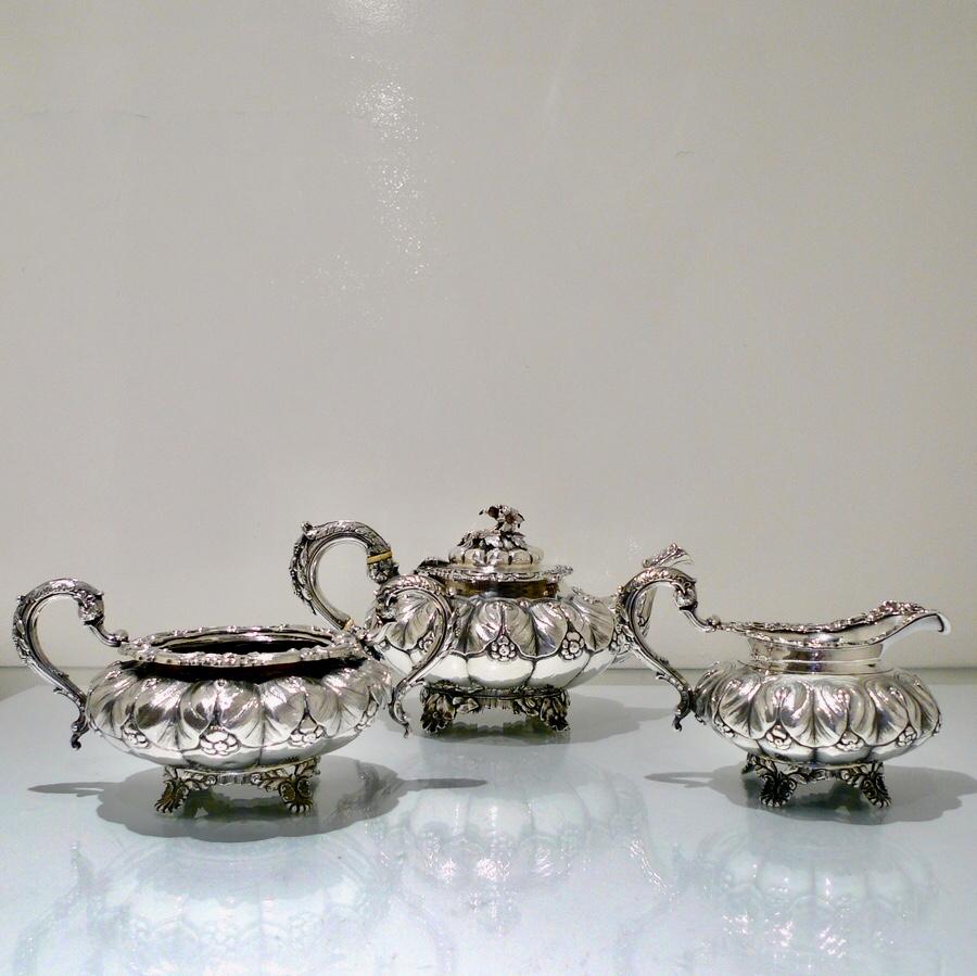 A truly beautiful and extremely stylish shaped circular three-piece teaset decorated with ornate floral upper chasing and lower plain formed flute designs for decorative contrast. The splendidly ornate scroll formed handle rounds off a beautifully