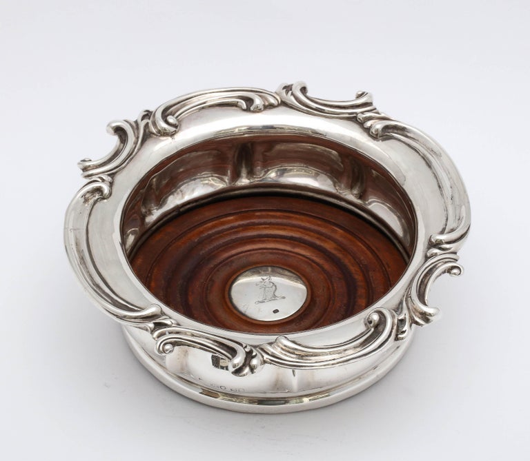 William IV, sterling silver-mounted wood wine/champagne bottle coaster, Birmingham, England, year-hallmarked for 1836. Lovely scalloped design. Inside part of wooden base has a sterling silver disc with an armorial of a griffin etched into it. The