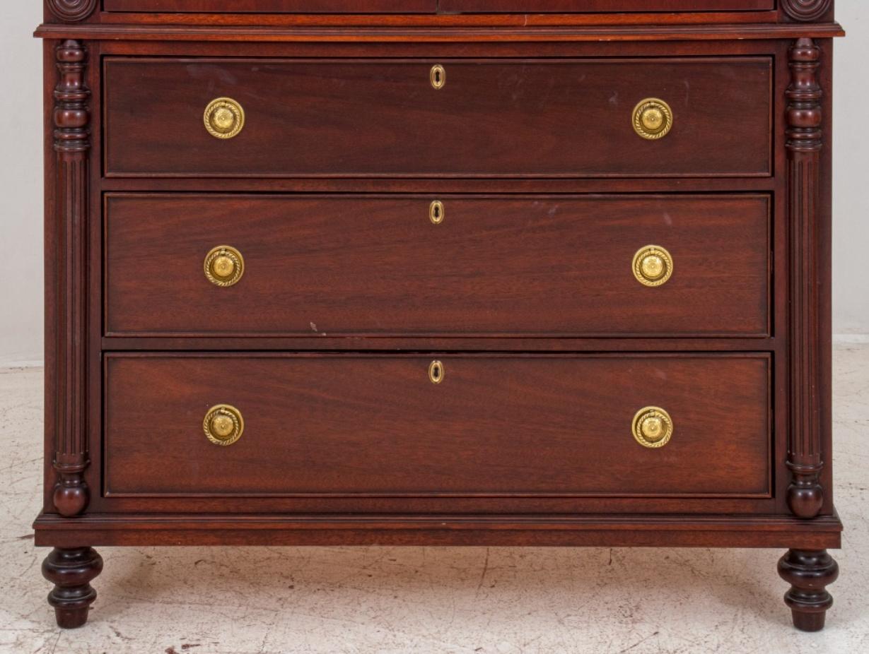 William IV style carved mahogany linen press, with molded cornice above a case fitted with two paneled cupboard doors, the lower section fitted with three graduated long drawers, raised on turned feet. 88