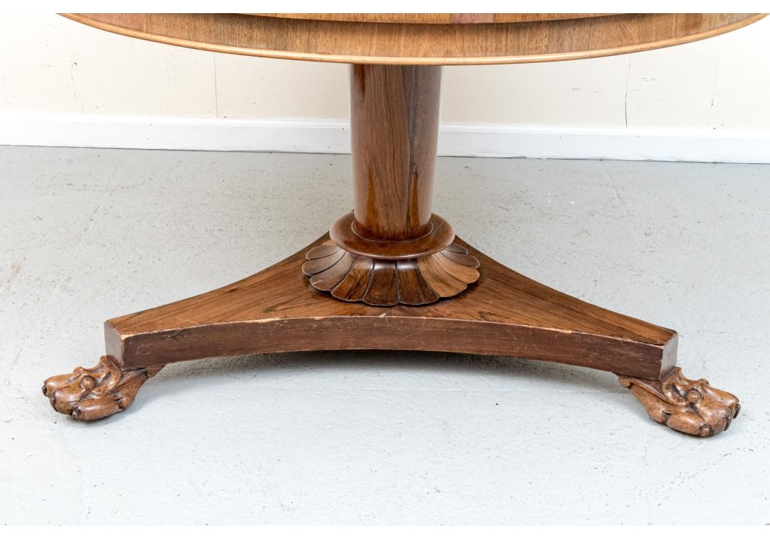 Table de salle à manger ou de centre à piédestal en bois de couleur miel, de style William IV, avec un plateau et une frise bien figurés et des garnitures rondes. La table avec un piédestal légèrement effilé surmonté d'une base triangulaire avec un