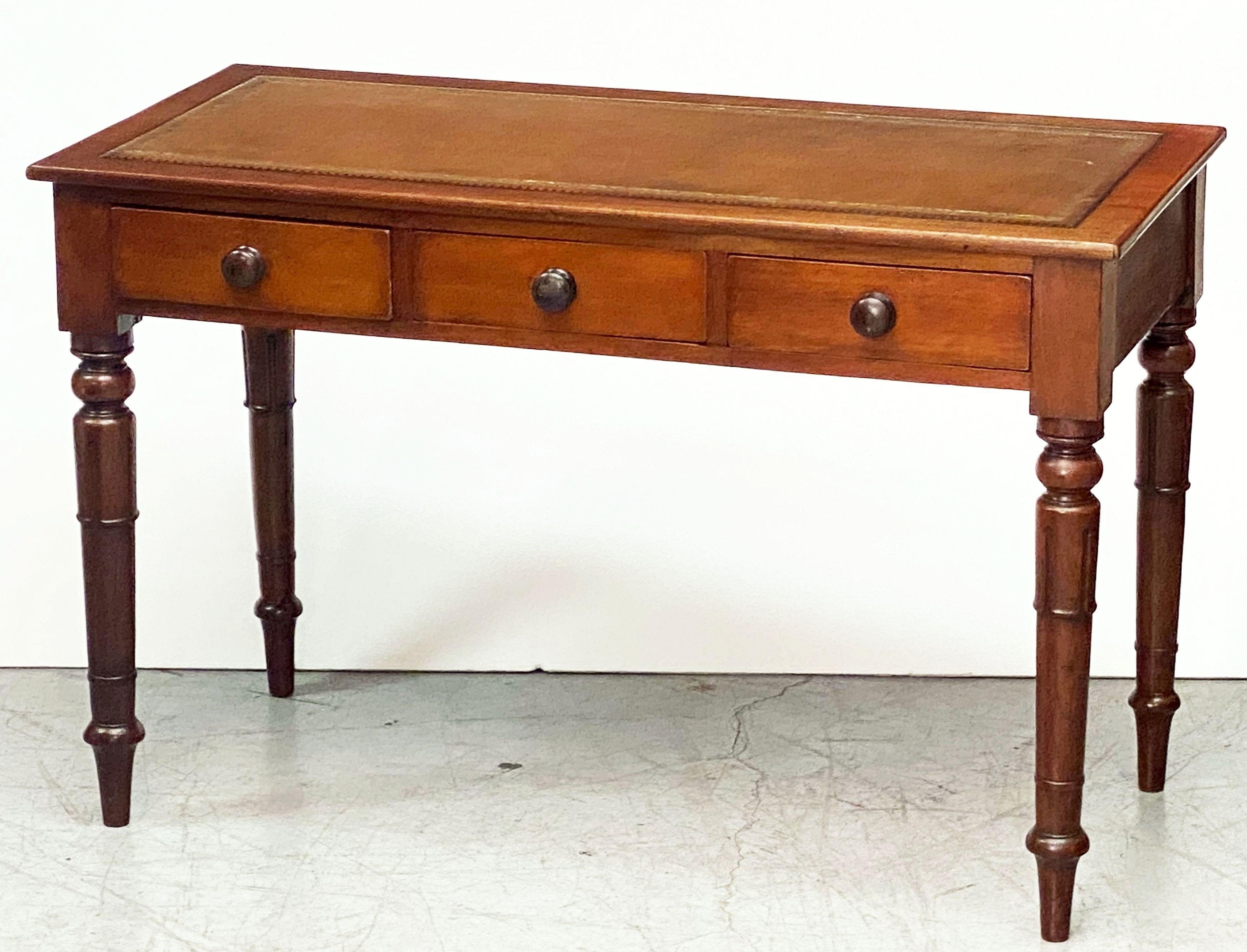 A fine English writing desk or library table of mahogany, from the William IV period, featuring a leather top embossed with gilt edge, over a frieze of three drawers - each with knob pull, resting on handsomely turned legs.

Inside left drawer has