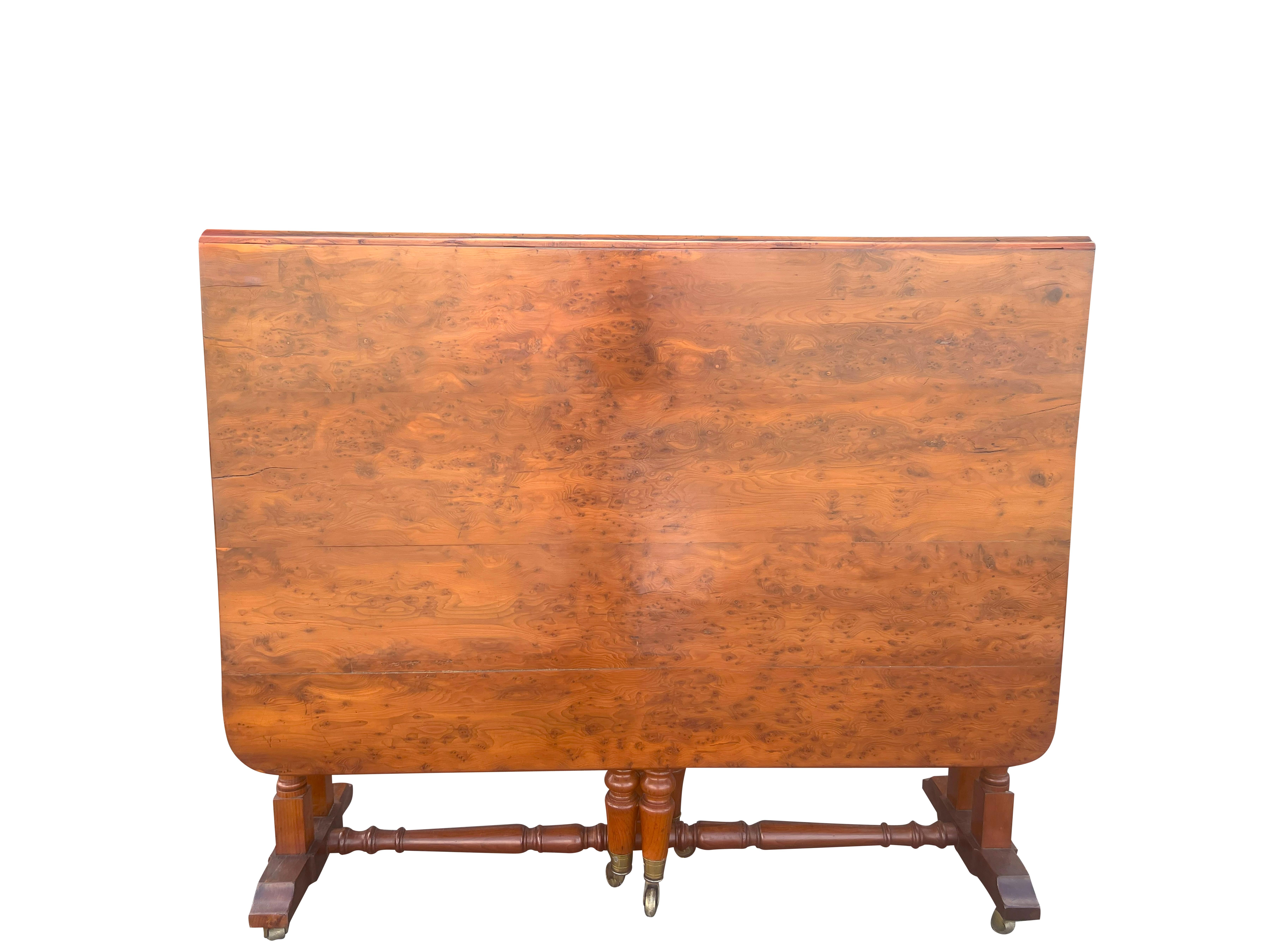 Unusual being made entirely of solid yew wood. Rectangular with hinged drop leaves and turned legs with casters. Handy as a pull out table. Very sturdy. Estate of Bartlett Burnap. Palm Beach.