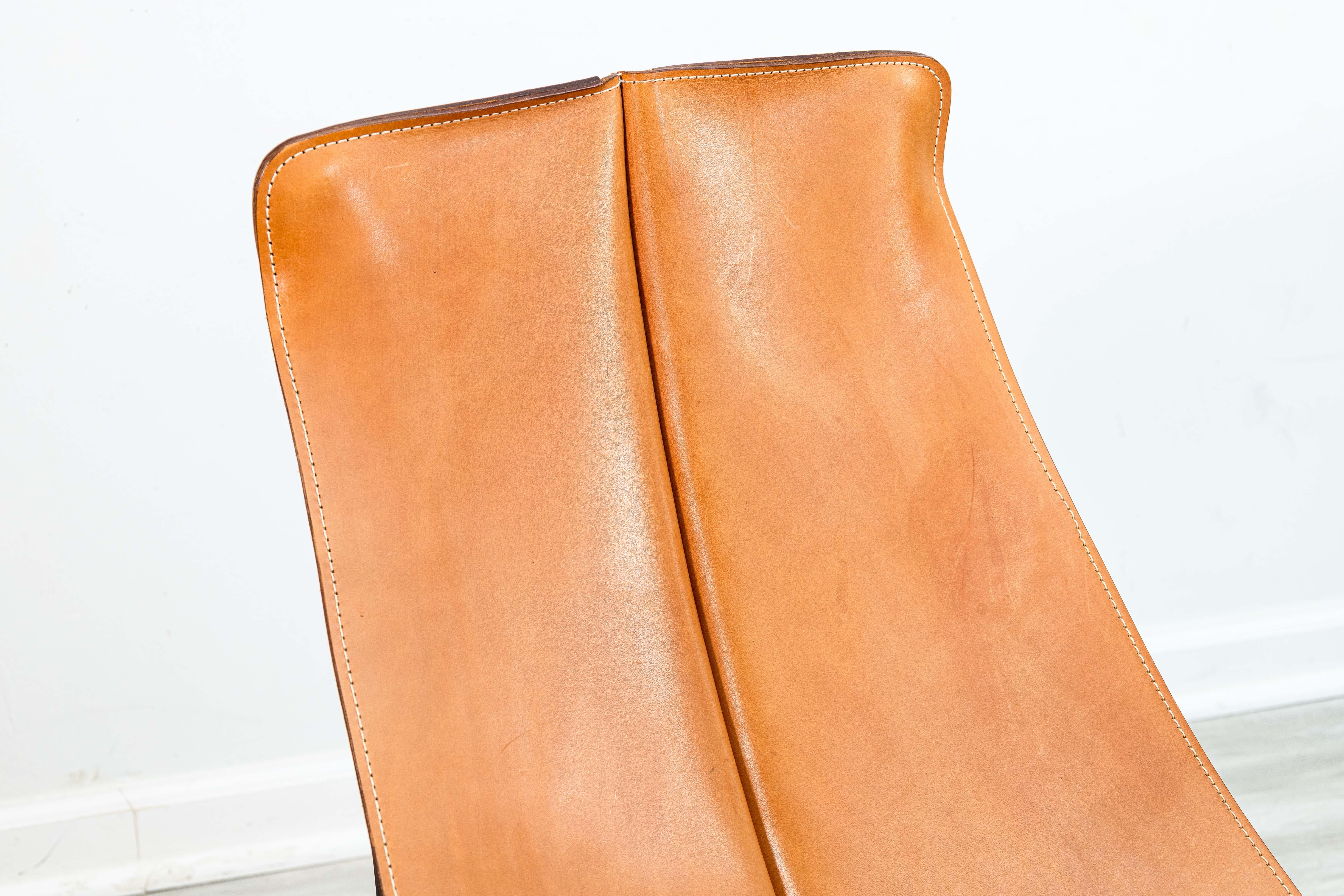 A William Katavolos for Leathercrafters sling lounge chair set. This beautiful 1970s accent lounge chair features a chair and ottoman. Each piece has an iconic design by Katavolos featuring a leather and iron construction. The leather on the chair