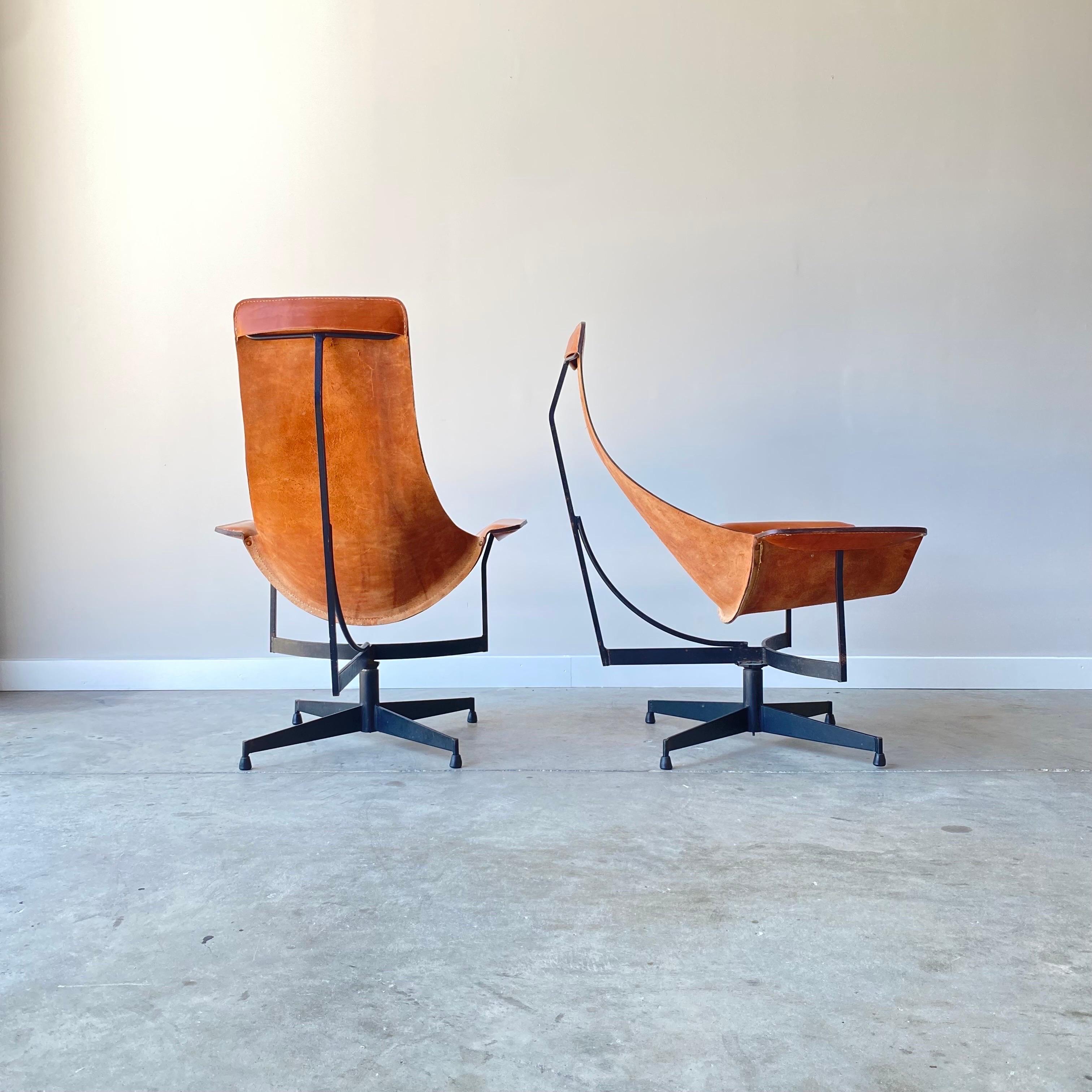 A stunning pair of leather and iron sling chairs by William Katavolos.  The original leather is in great condition and shows age appropriate wear and signs of use.  These swivel and are very comfortable and offer a striking silhouette.   

An all