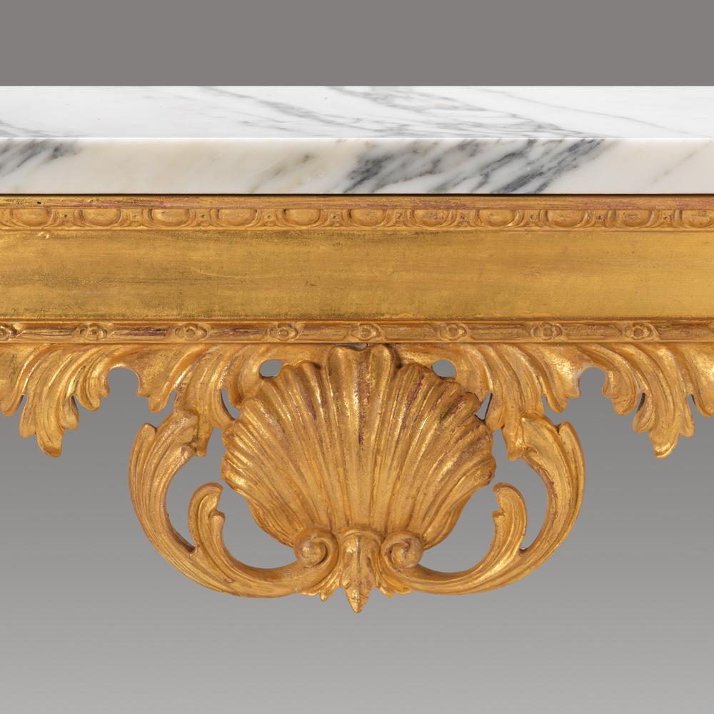 An exceptional William Kent design, wall-mounted, marble-topped console table. The William Kent Audley Console has a stylised carved shell to the frieze and cabriole inverted legs, terminating in lion’s claw feet, resting upon a carved edged