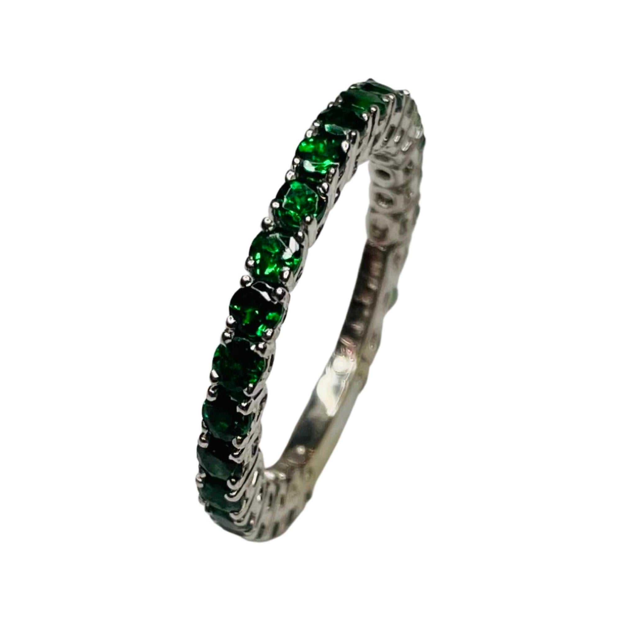 William Levine Fine Jewels 18K White Gold Natural Tsavorite Garnet Ring. There are 25, diamond cut Tsavorite Garnets weighing 1.54 carats. They are prong set. The ring is 2.2 mm wide. The ring is finger size 6.25 but can be sized for an additional