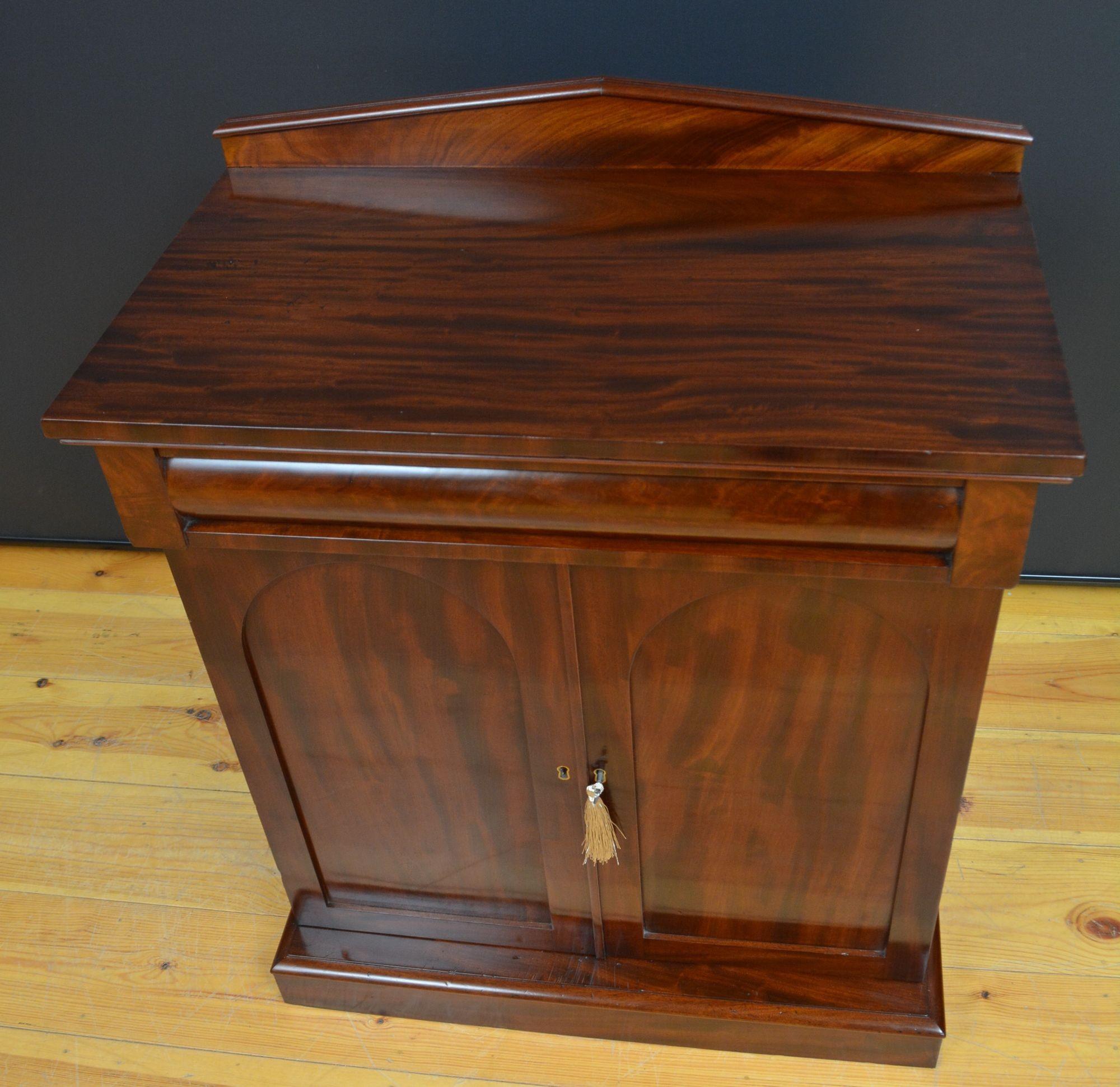 ST060 William IV Mahogany Chiffonier of diminutive proportions having an architectural pediment to the back, a figured mahogany top above a inset cylindrical drawer and a pair of panelled flame mahogany doors fitted with working lock and key,