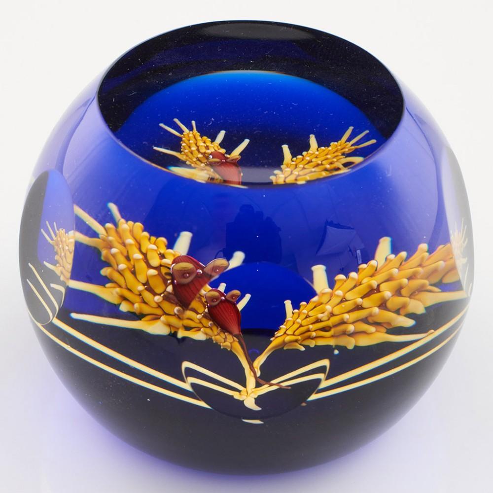 Heading : A William Manson Caithness Harvest Mouse Lampwork Limited Edition Paperweight 1988
Date : 1988
Origin : Scotland
Features : A Lampwork harvest mouse, wheat ears and on a blue ground with top window and side facet cuts
Marks : Harvest Mouse