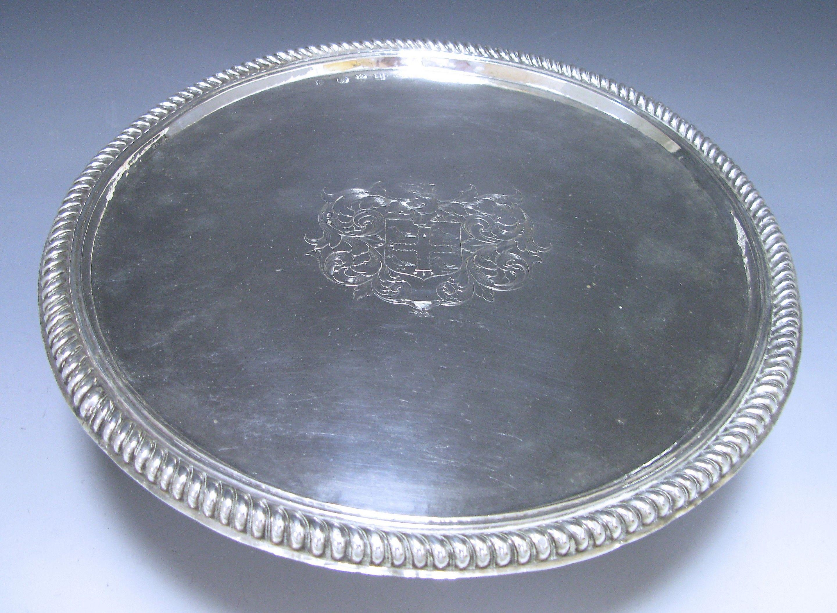 A distinctive William & Mary Antique Silver Tazza of plain circular form onto a cylindrical spreading foot. The surface of the tazza is embellished in the centre with, a contemporary coat of arms and has an impressive gadroon decorated border. The