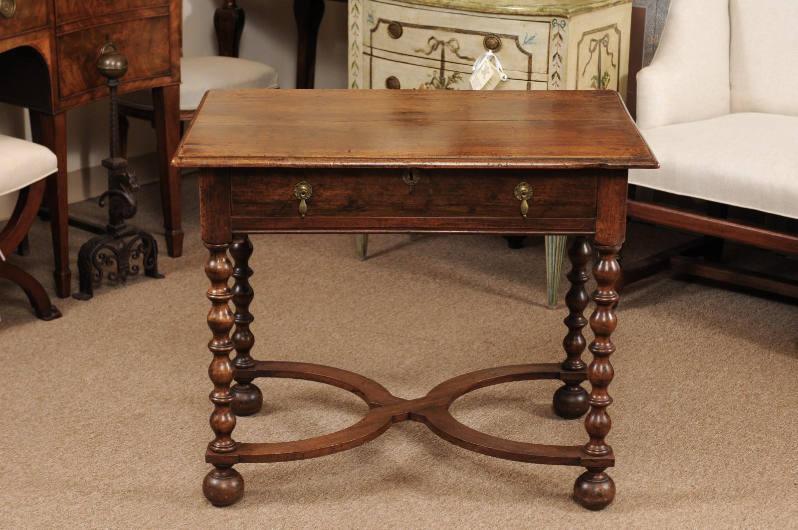 The William & Mary English side table with rectangular top with molded edge and drawer below with brass tear drop pulls. The bobbin turned legs joined by X-stretcher ending in rounded feet. 

  
