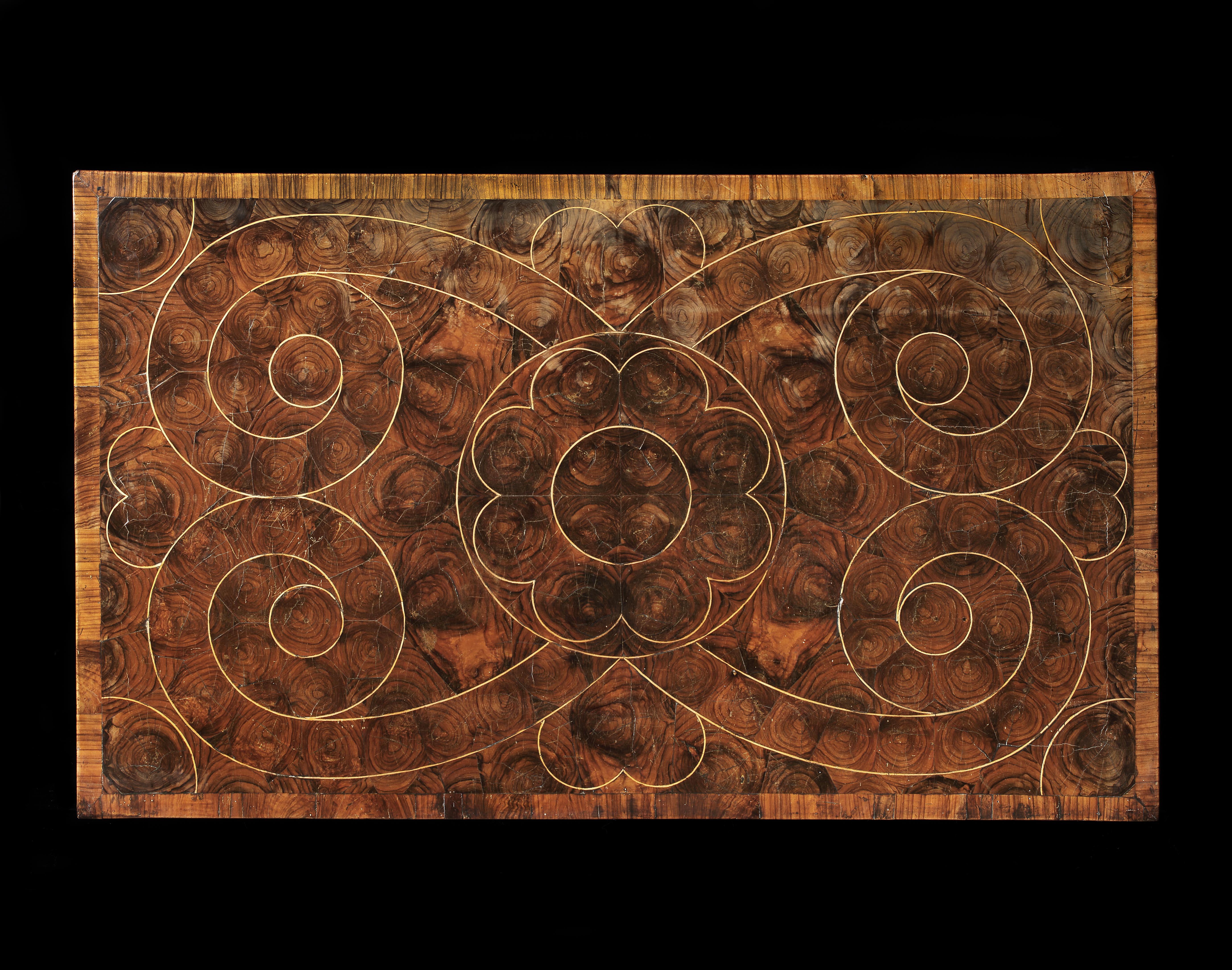 A William & Mary olivewood oyster veneered chest of drawers, the top inlaid with geometric lines in holly above two short and three long drawer fronts similarly inlaid. Standing on bun feet.



This early chest of drawers retains a wonderful