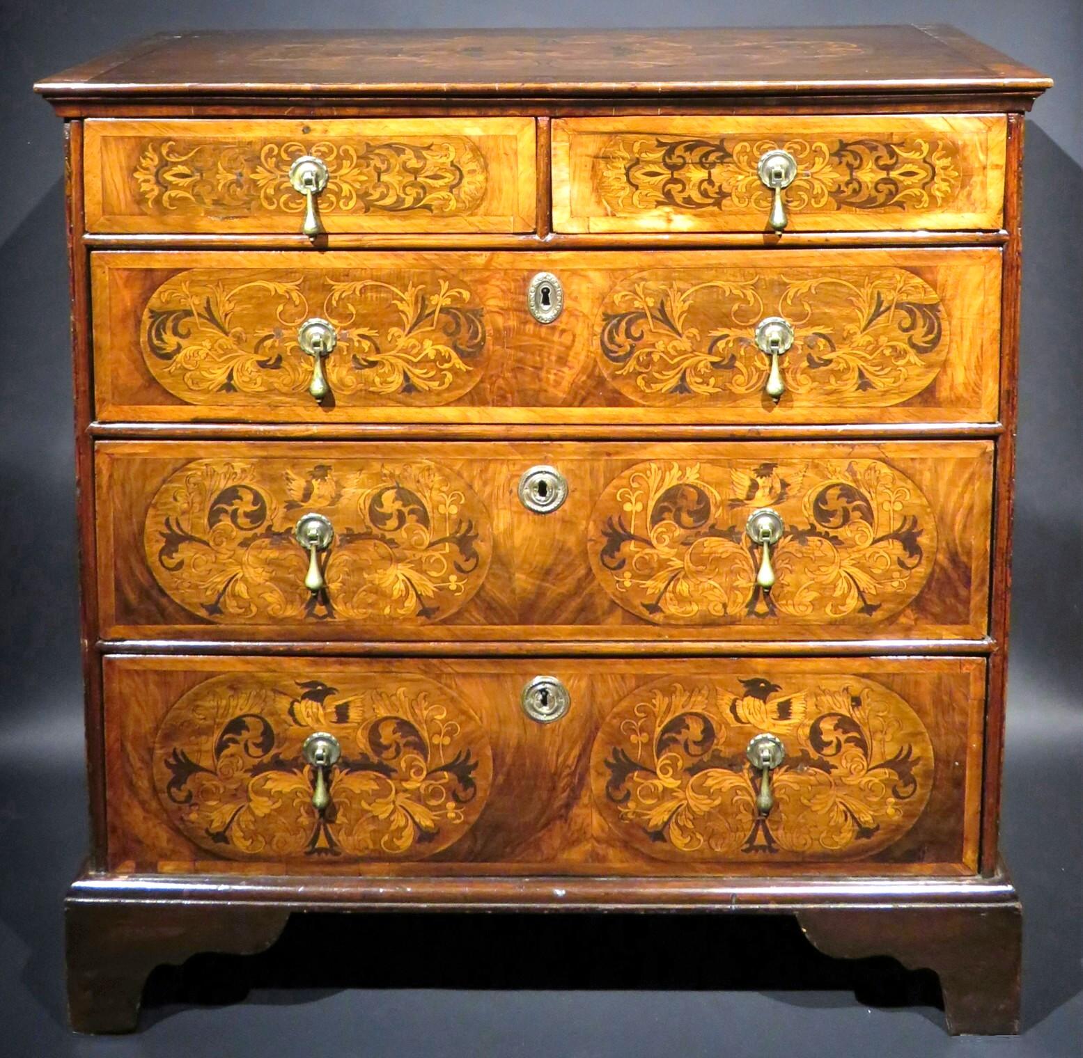 An outstanding and finely proportioned William & Mary walnut chest of drawers, the case showing a cross-banded and inlaid top above a pair of short drawers overtop three tiers of graduated full width drawers, their fronts featuring marquetry motifs
