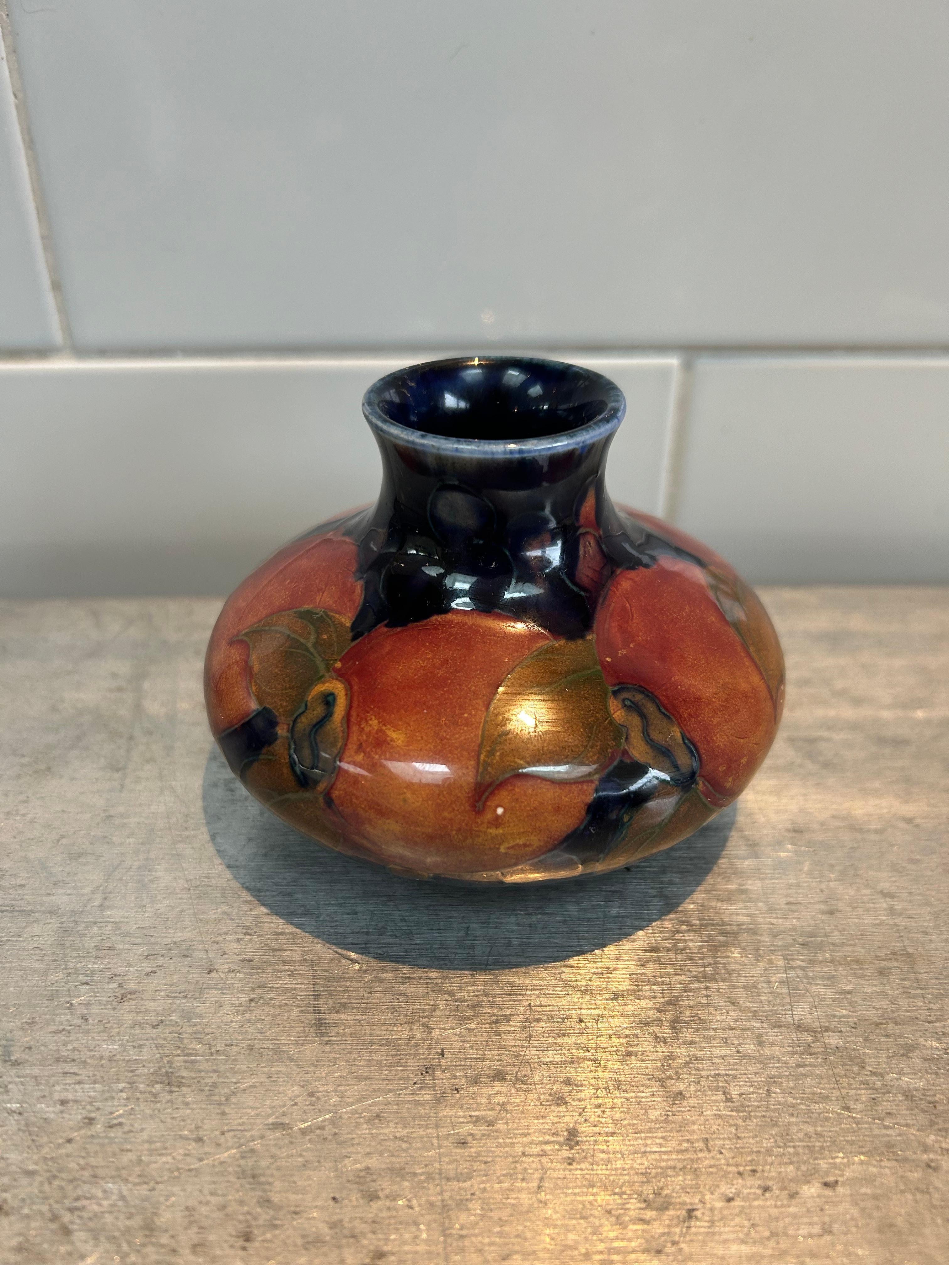 This sweet sized vintage vase features the pomegranate design on a dark cobalt blue background. It was designed by William Moorcroft and produced at Burslem. The base is reassuringly signed in green and also features impressed/stamped markings
