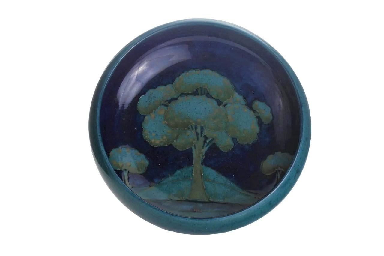 Superbe coupe creuse de William Moorcroft Pottery à motif de paysage d'arbre bleu au clair de lune.
Ce ravissant bol présente des arbres bleu moyen bordés de tubes avec des reflets bruns sur un fond bleu cobalt gradué. Il est signé en vert par