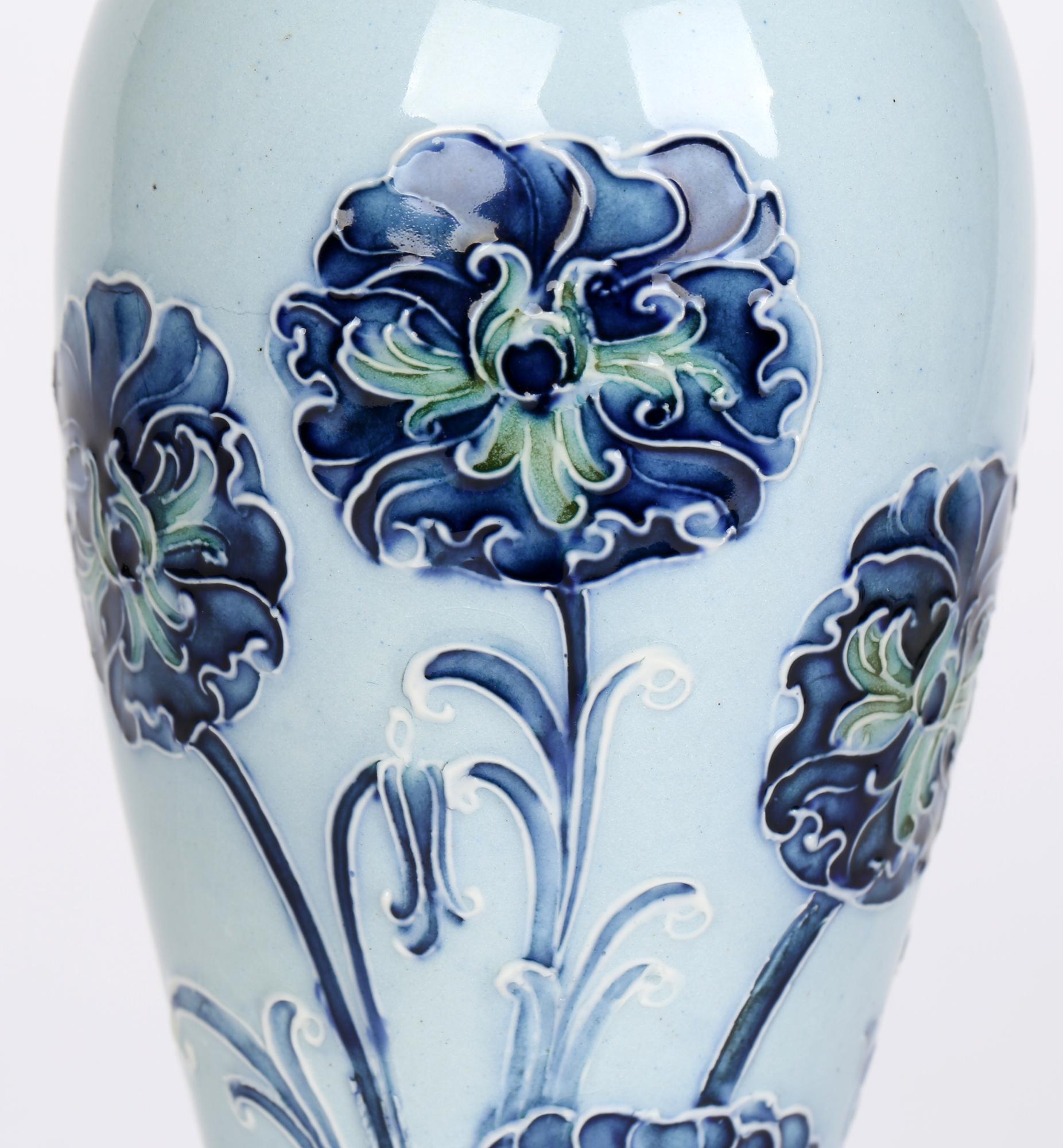 Art Nouveau James MacIntyre & Co. Florian Ware tall elegantly shaped vase decorated with tube lined carnations designed by William Moorcroft (English, 1872-1945) and dating from around 1900. William Moorcroft started out as a designer before