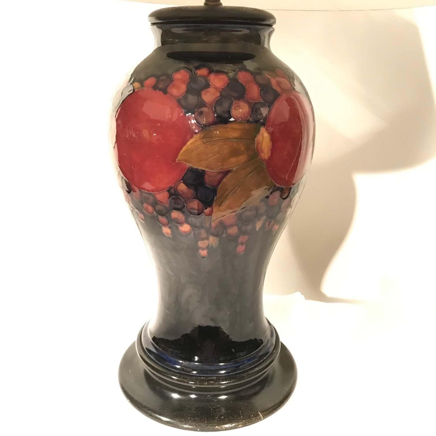 A stunning large William Moorcroft Pottery pomegranate baluster vase mounted as a table lamp, circa 1925.
Decorated in a classic Moorcroft pattern, featuring five pomegranate fruits one which is open, along with clusters of berries and leaves all on