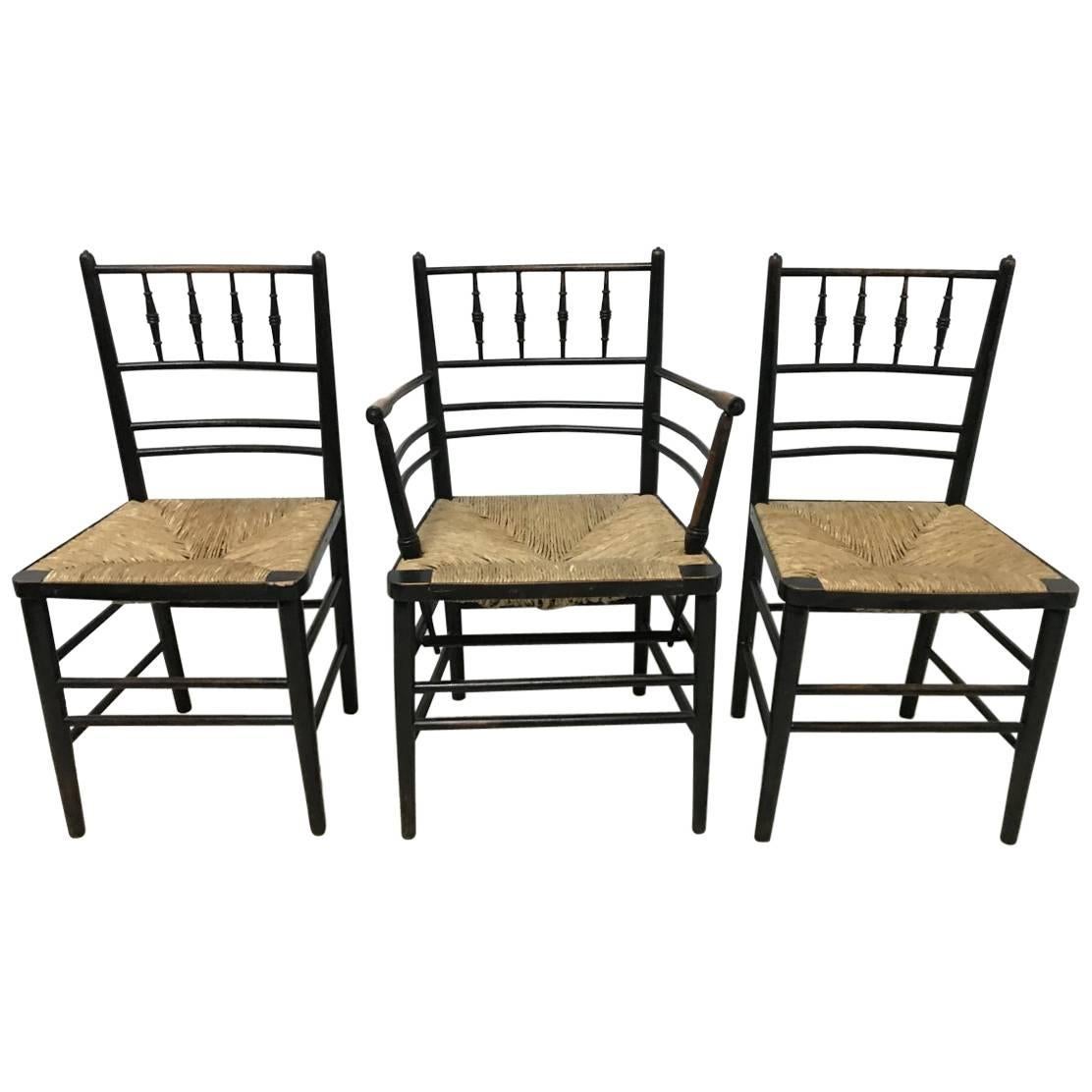 William Morris, Five Ebonized Rush Seat Sussex Side Chairs and Matching Armchair