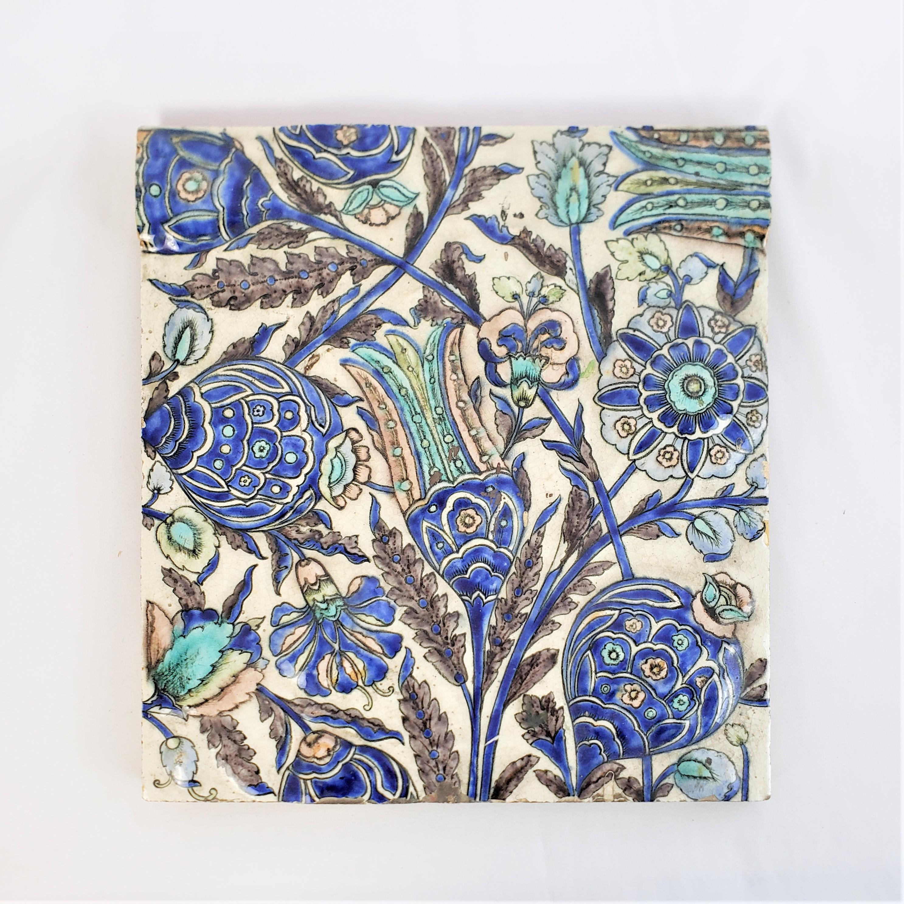 This large antique decorative tile was made by Craven, Dunnil & Jackfield of England in approximately 1890 and done in a period Art Nouveau style. The tile is done with a thick pottery with a glossy cream ground on the top with a number of stylized
