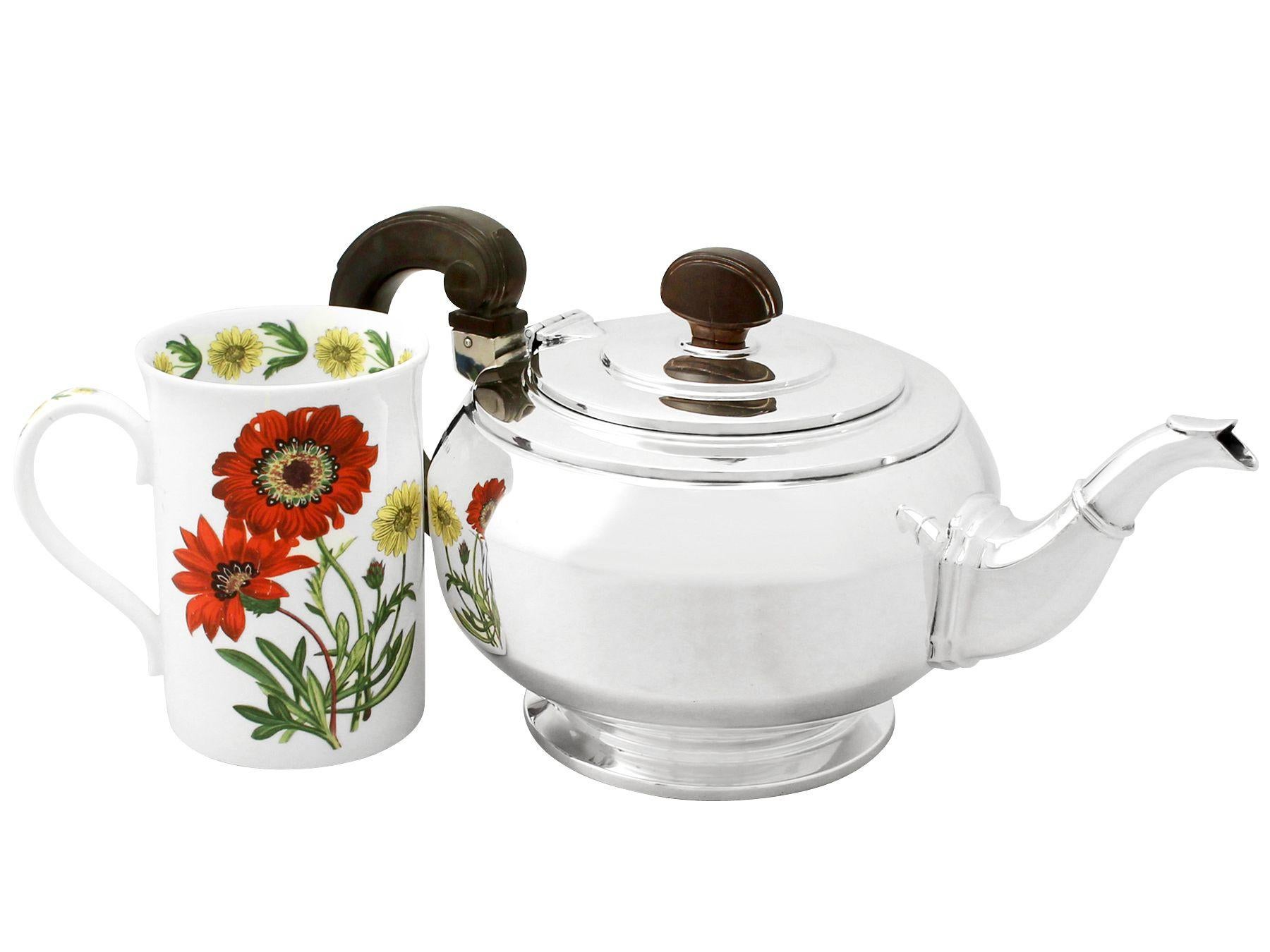 A fine and impressive antique George VI English sterling silver teapot in the Art Deco style, an addition to our silver teaware collection.

This fine antique George VI sterling silver teapot has a plain circular rounded form onto a circular stepped
