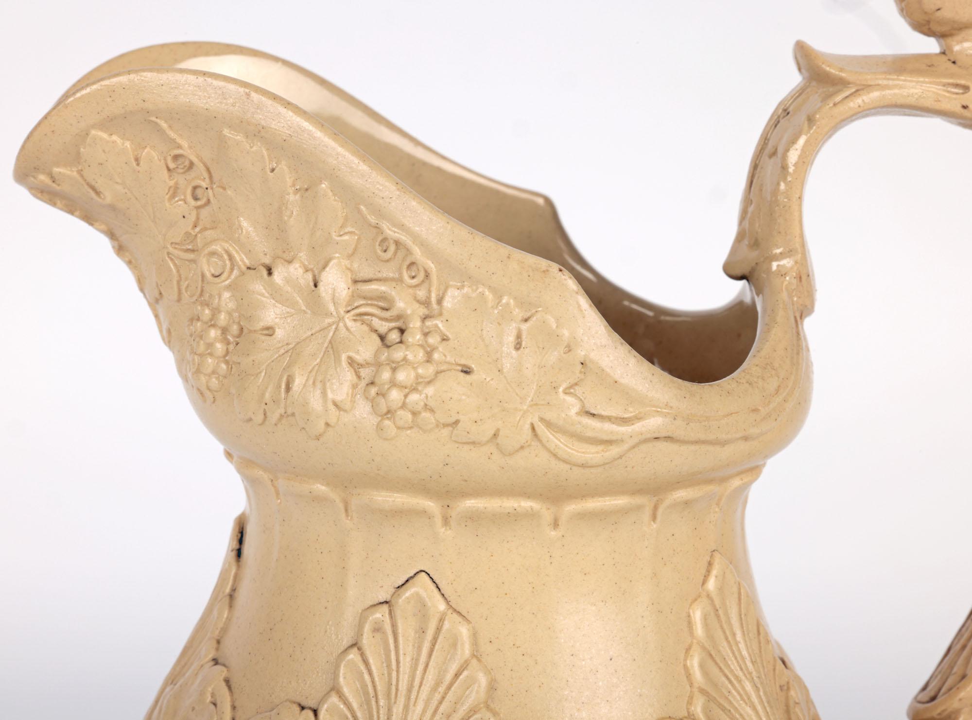 Une ancienne cruche en drabware anglaise de qualité représentant Bacchus et Pan, réalisée par le célèbre fabricant William Ridgway et datant d'environ 1834. La cruche en grès repose sur un piédestal étroit et rond, de forme arrondie et bulbeuse,