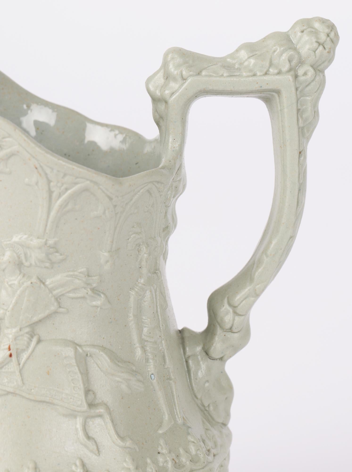 A scarce and exceptional antique English ceramic jug decorated in the Jousting Knights pattern by William Ridgway and dating from around 1840. The jug of miniature size is made in a green/grey drabware stoneware and is crisply molded with two