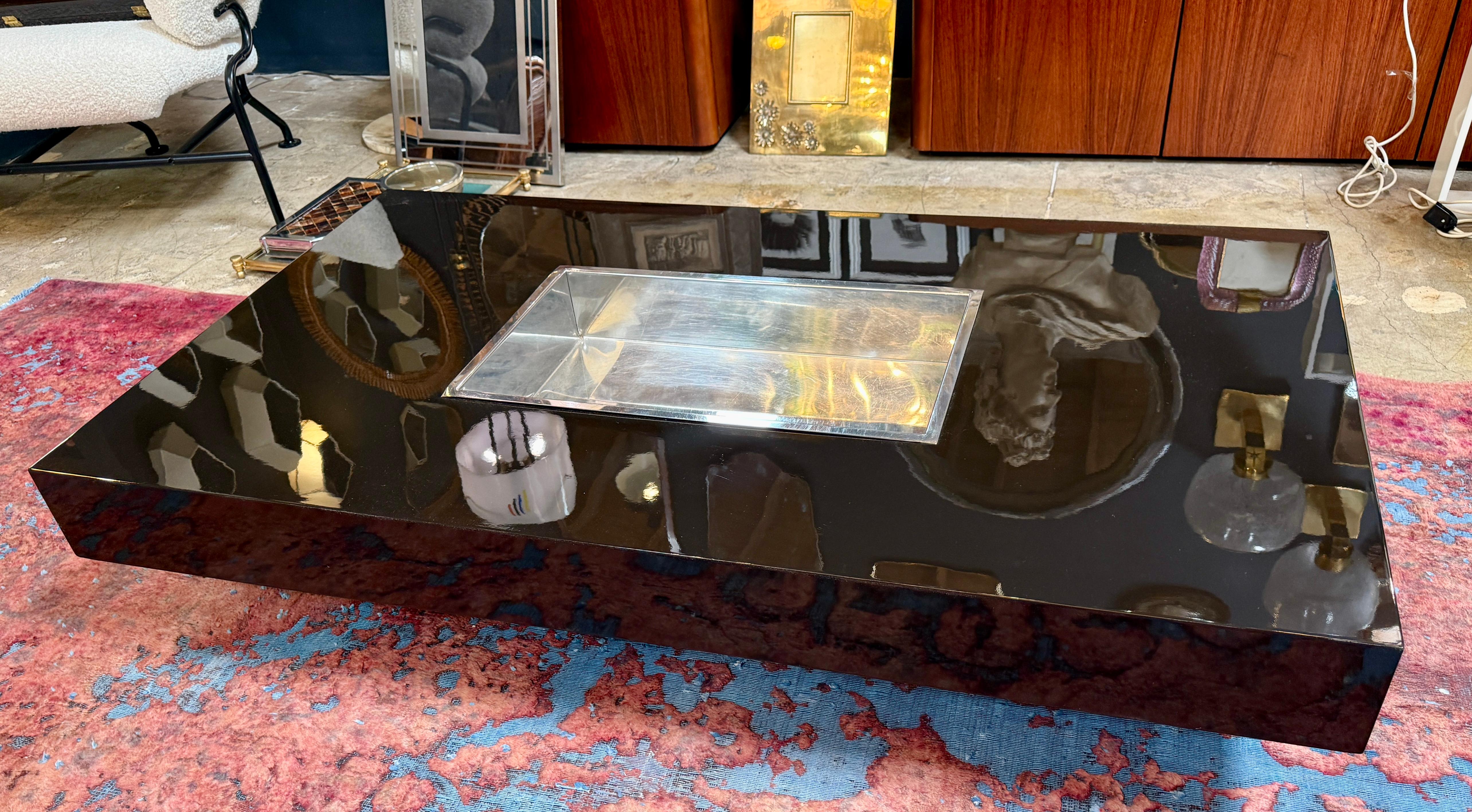A striking and rare coffee table by Italian designer William Rizzo, dating from the 1970s. This piece exemplifies Rizzo’s signature minimalism and bold use of reflective surfaces. The table features a sleek, high-gloss black lacquered body with
