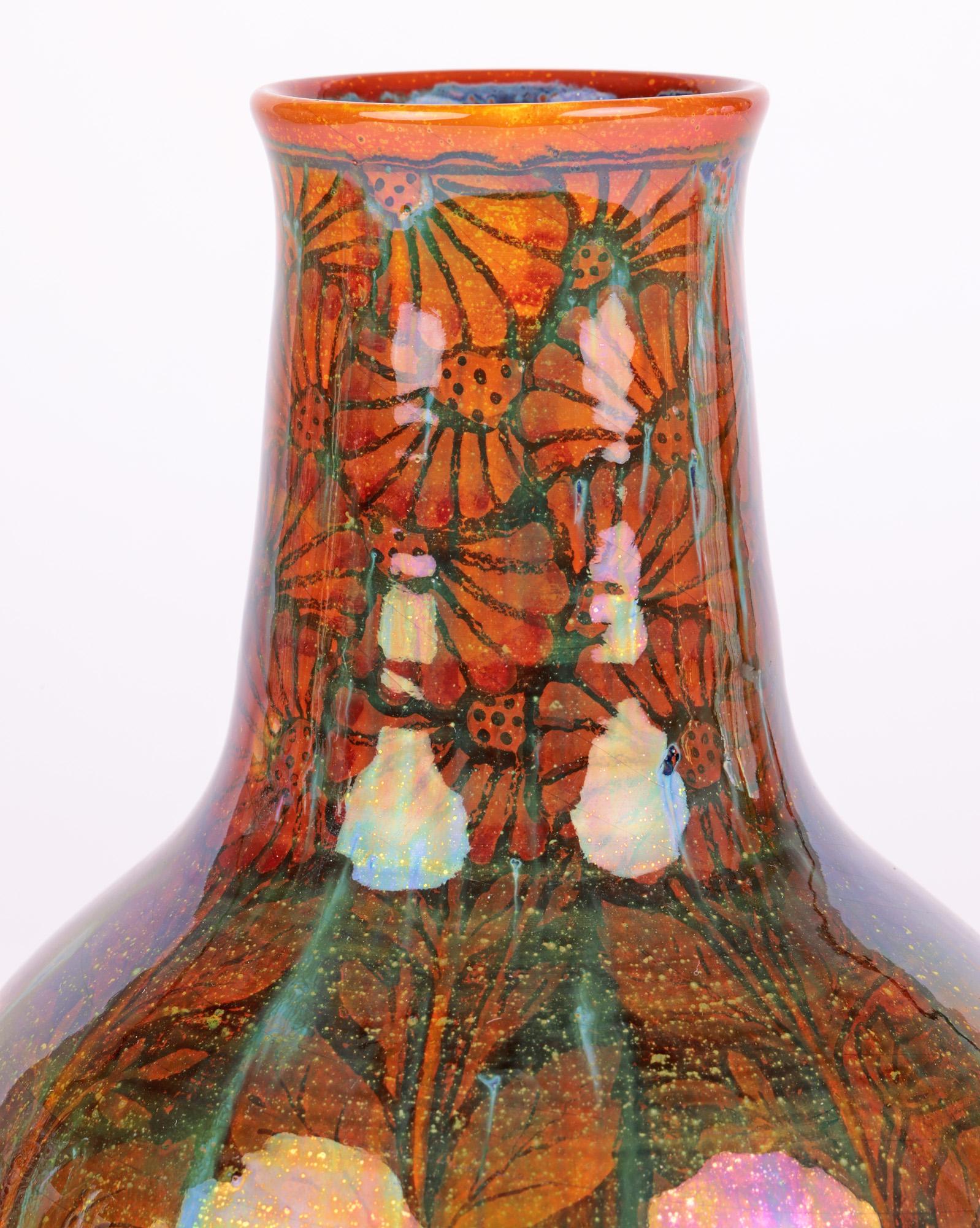 A stylish Pilkingtons Royal Lancastrian art pottery lustre vase decorated with flowering shrubs by renowned artist William S Mycock (British, 1872-1950) dating from around 1915. The finely potted bottle shaped vase stands on a wide round unglazed