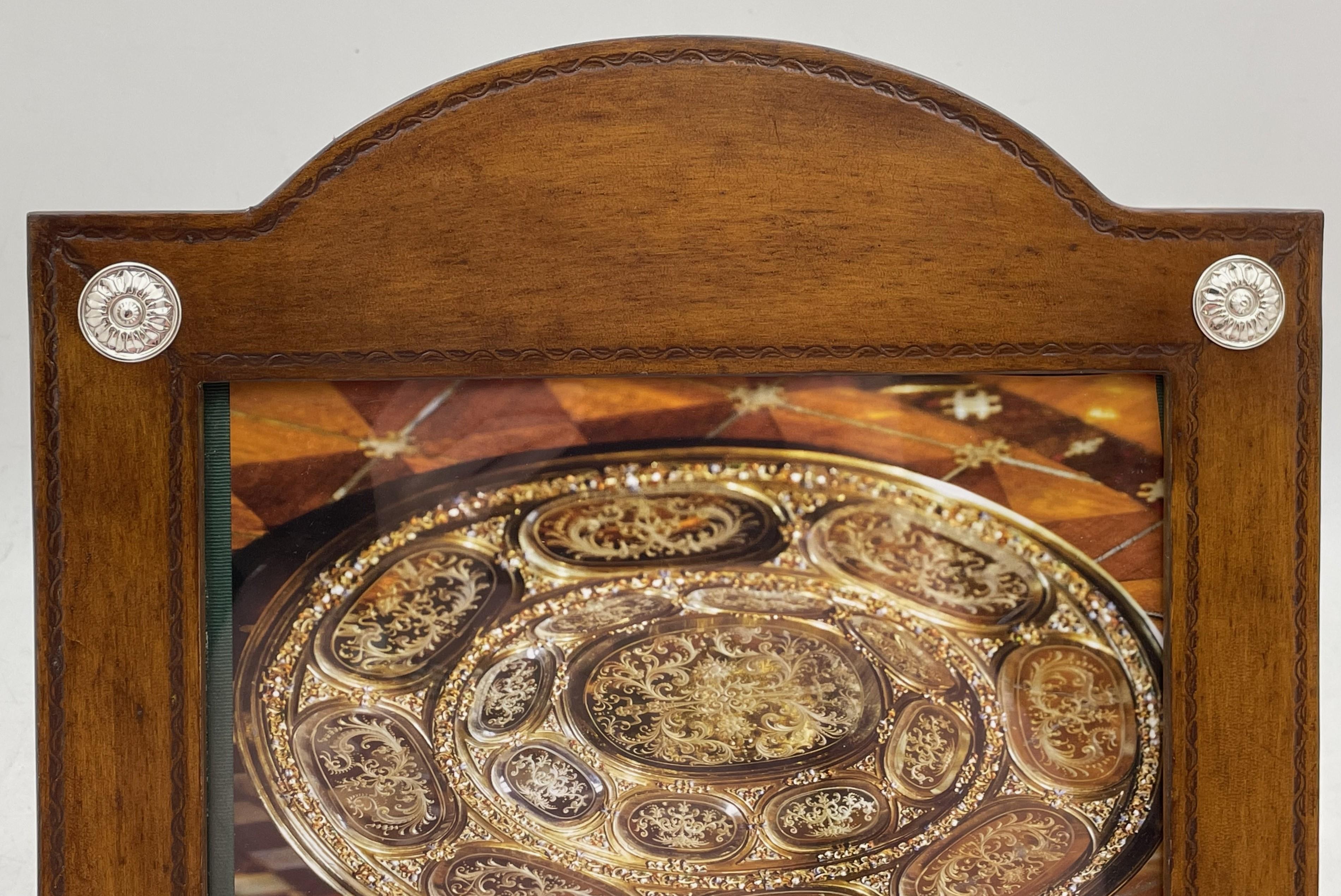 Cadre photo en cuir William Scott avec motifs floraux en argent sterling appliqués. Il mesure 12'' sur 12'' (les dimensions intérieures sont de 9'' sur 7'') et porte les poinçons indiqués. Il est en état neuf et est vendu dans sa pochette d'origine.