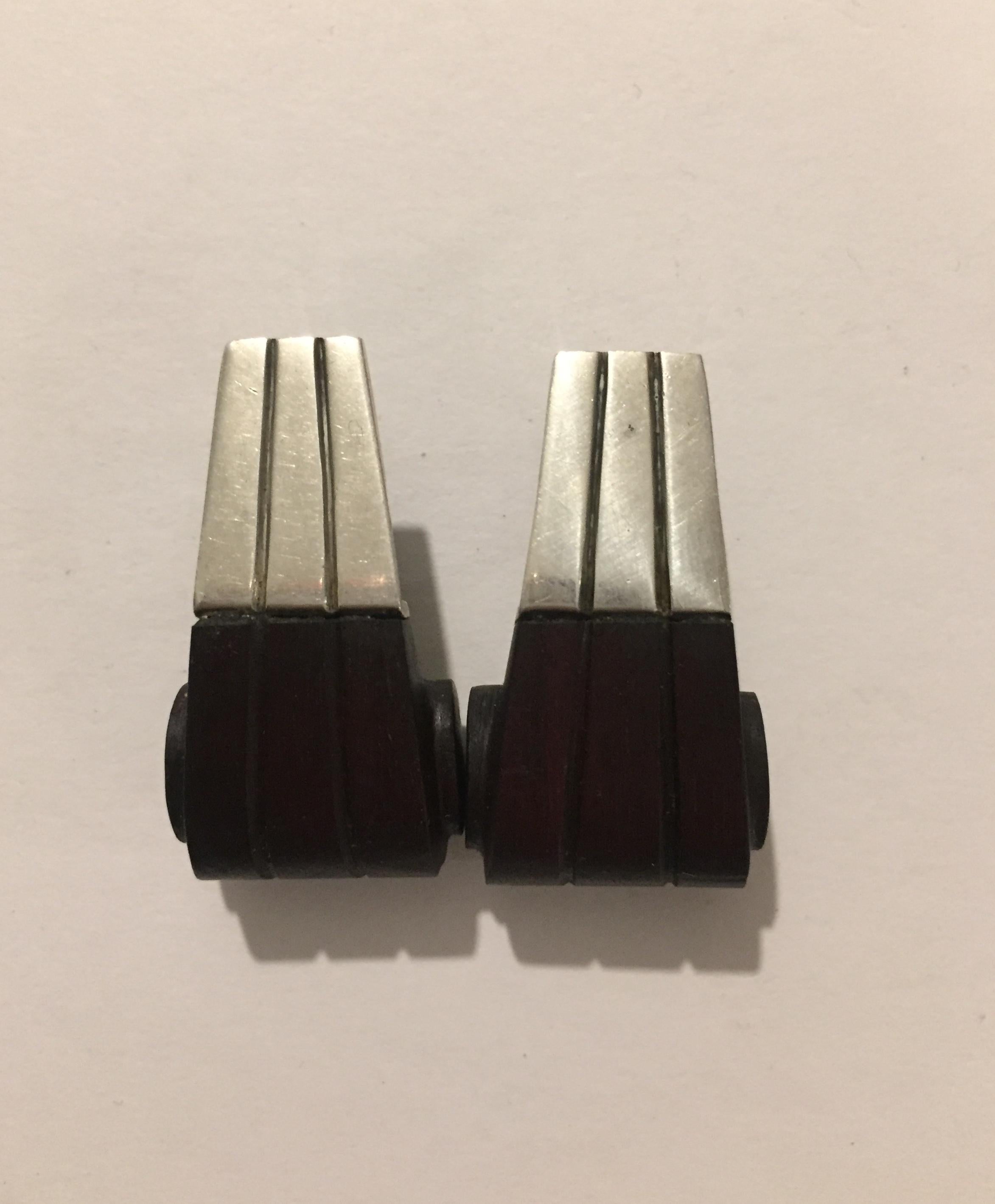 Rare pair of Taxco silver and rosewood earring by American designer William Spratling. The curled design shows striations in both wood and silver. Both earrings sealed on back.

According to Spratling Silver Reference, this earrings are feature in