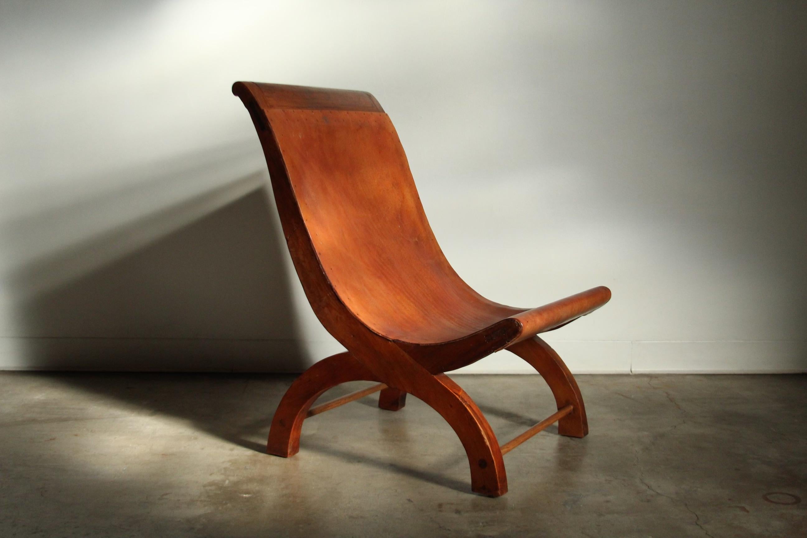 A rare, signed Butaque chair designed by William Spratling, produced in his workshop in Taxco, Mexico in the 1940’s. The chair is handmade of Mexican sabino wood and thick cognac leather which is tacked along the edges. It is branded with the iconic