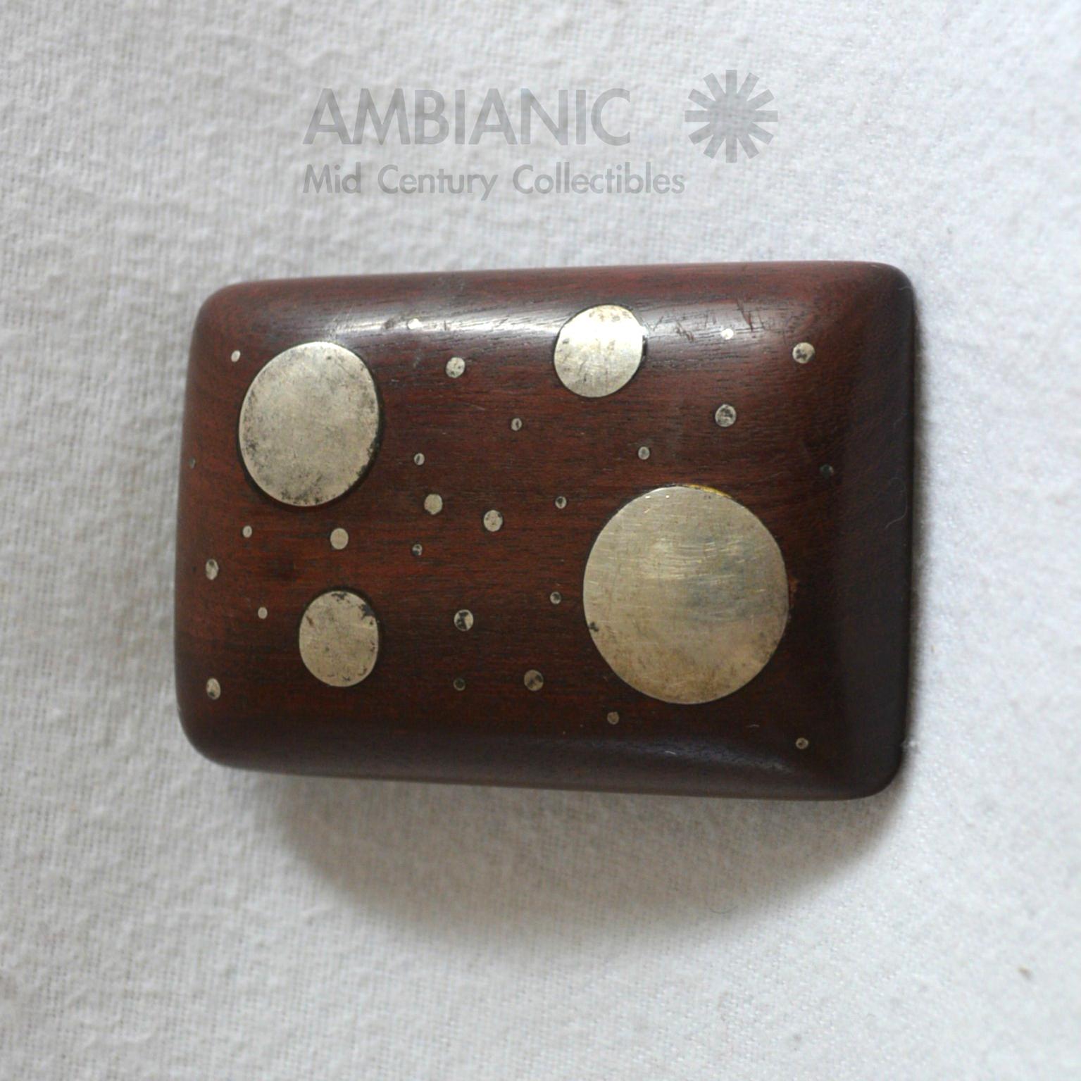 Mexican modernist belt buckle sterling silver circles encrusted in solid mahogany wood.
Mexico, circa 1960s. Attributed to William Spratling. No label.
Dimensions: 2 3/4