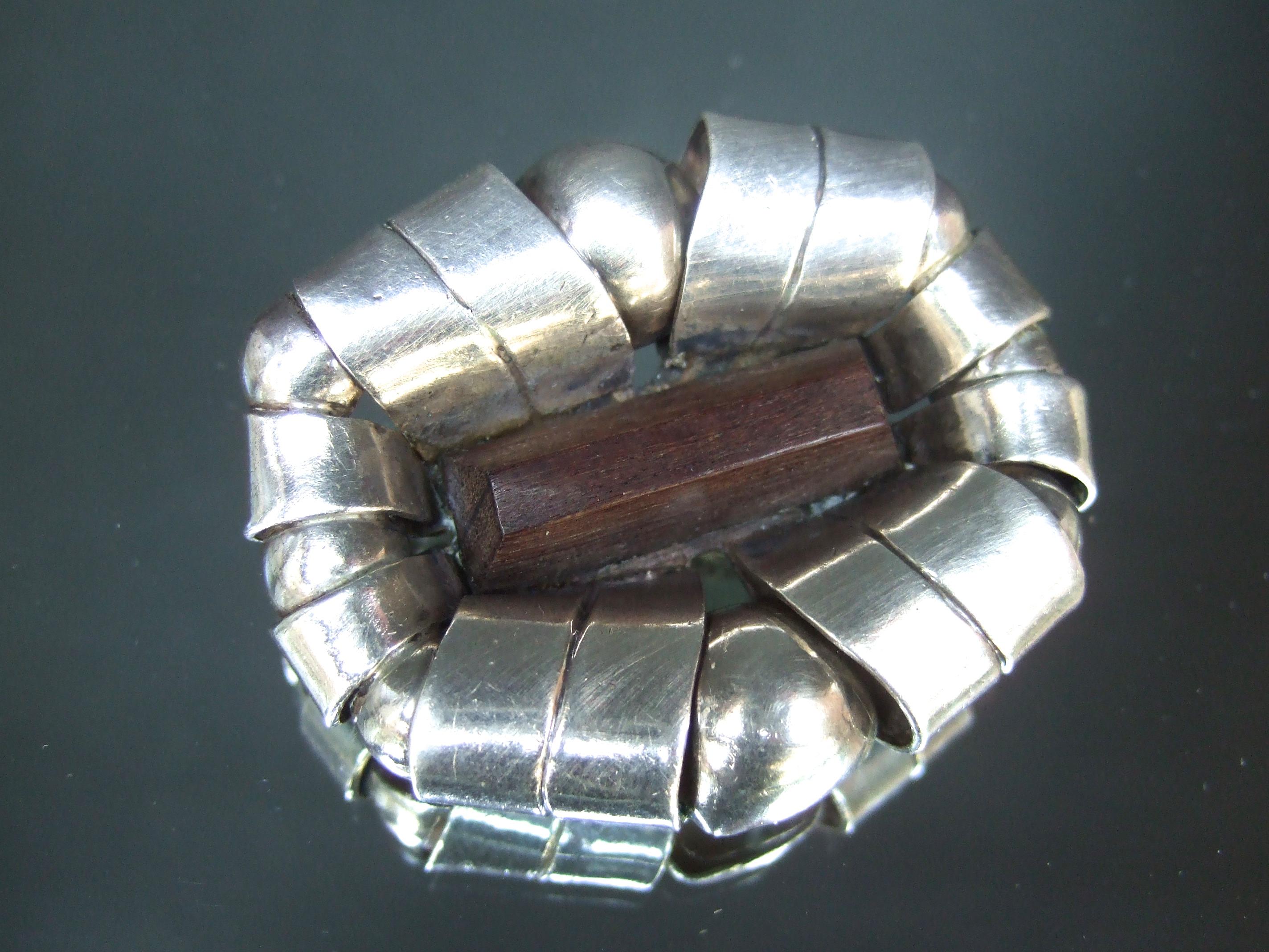William Spratling Rare early sterling silver wood design artisan brooch c 1940
The unique artisan brooch is designed with coiled bands of sterling silver 
The center is adorned with an elongated rectangular shaped carved
ebony wood tile

The