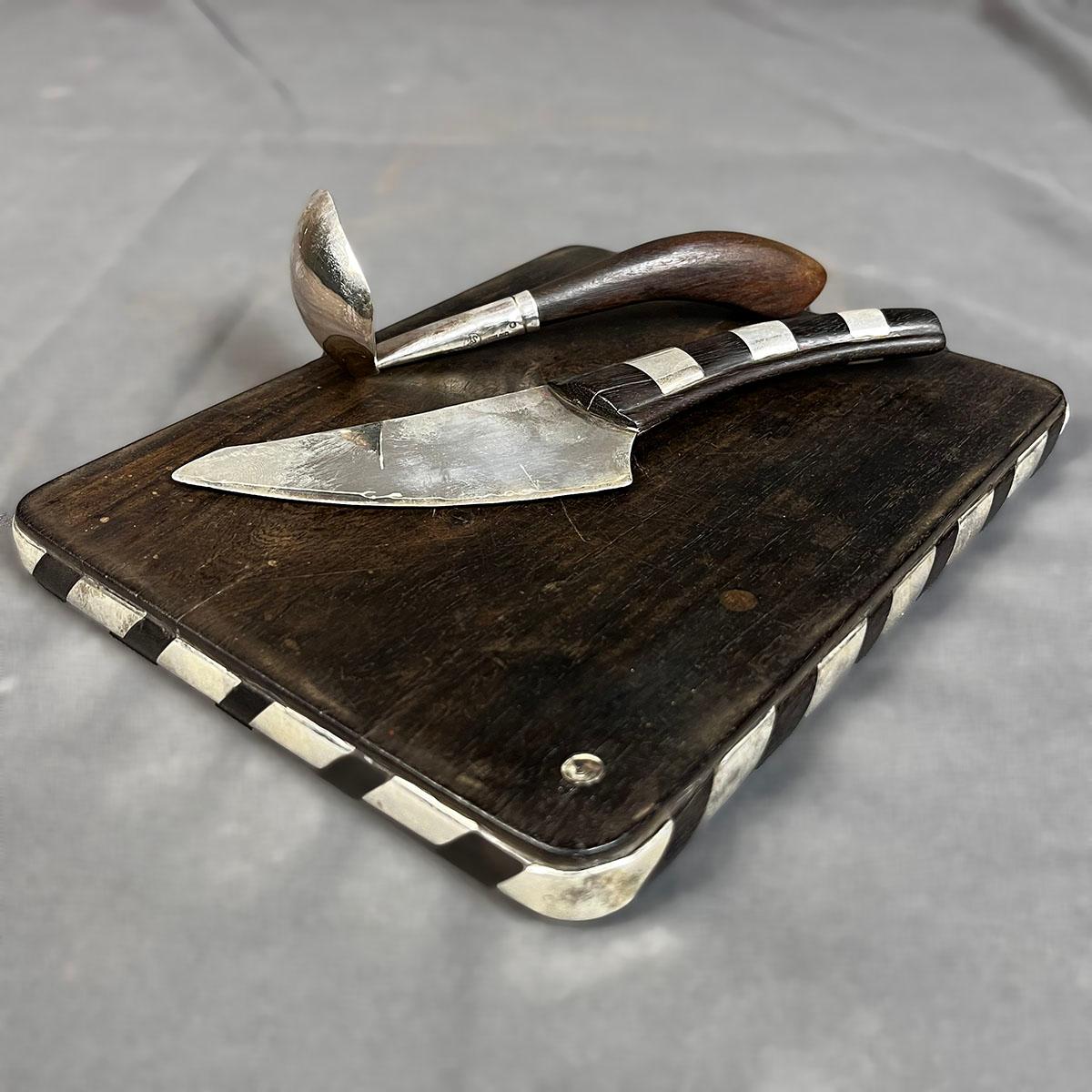 Un rare plateau à fromage en bois et en argent Sterling ca. 1958 en bois et argent Sterling avec couteau par le bijoutier, orfèvre et designer américain William Spratling. La planche de bois est incrustée de feuilles d'argent formant un dessin en