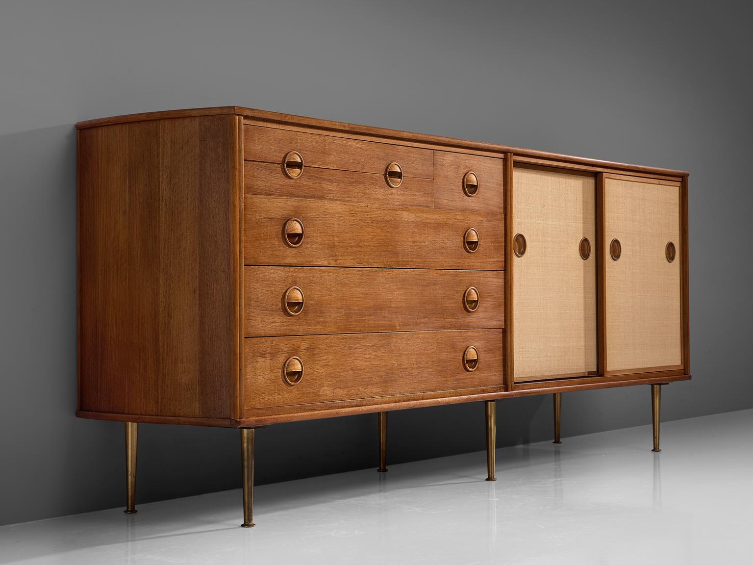 William Watting for Fristho, sideboard, teak, canvas and brass, 1960s. 

This cabinet by William Watting is executed with six high tapered brass legs which provides this piece with air and lightness. The sideboard is divided into three sections,