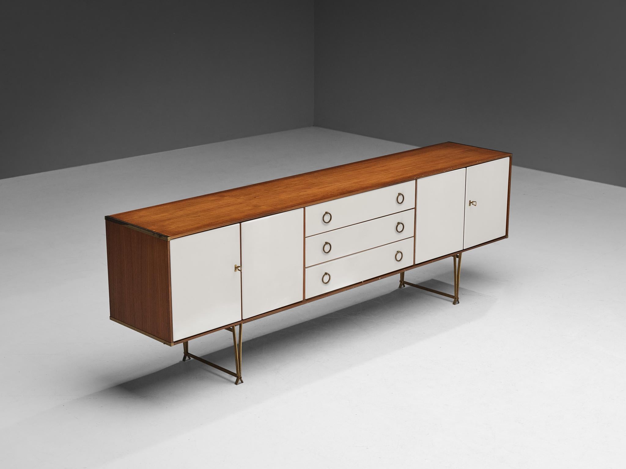 William Watting for Fristho, sideboard, teak, brass, lacquered wood, The Netherlands, 1950s. 

Elegant lacquered wooden sideboard with teak top and brass detailing. Very slim tapered brass legs that come together in two triangle shapes that makes