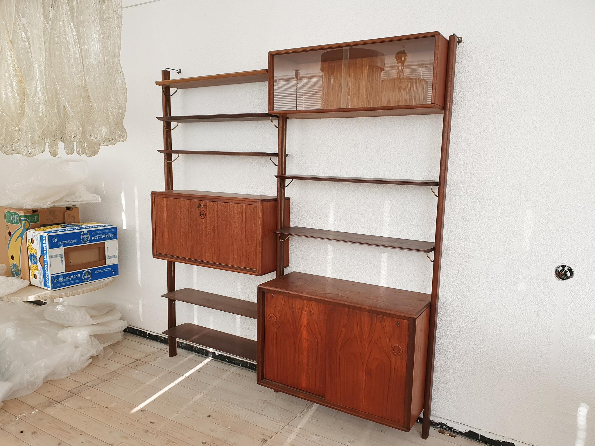 High quality wooden wall unit with brass hooks. Three cabinets and seven shelves.

7 x shelves: x cm
1x cabinet glass doors: cm (LxDxH)
1 x desk cabinet: cm (LxDxH)
1x cabinet with sliding doors: cm (LxDxH)