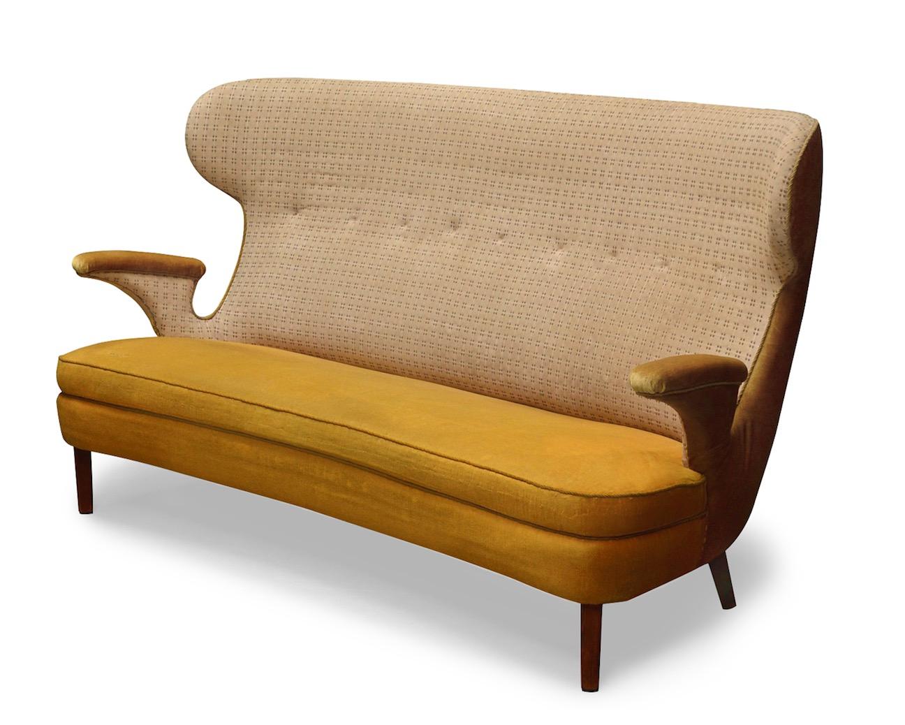 Ein seltenes, freistehendes Sofa auf Beinen aus dunkel polierter Buche. Der Sitz, die geschwungenen Armlehnen und die tiefgezogene Rückenlehne sind mit dem originalen, patinierten Bezug aus Polsterstoff versehen.
Hergestellt in den 1950er Jahren.