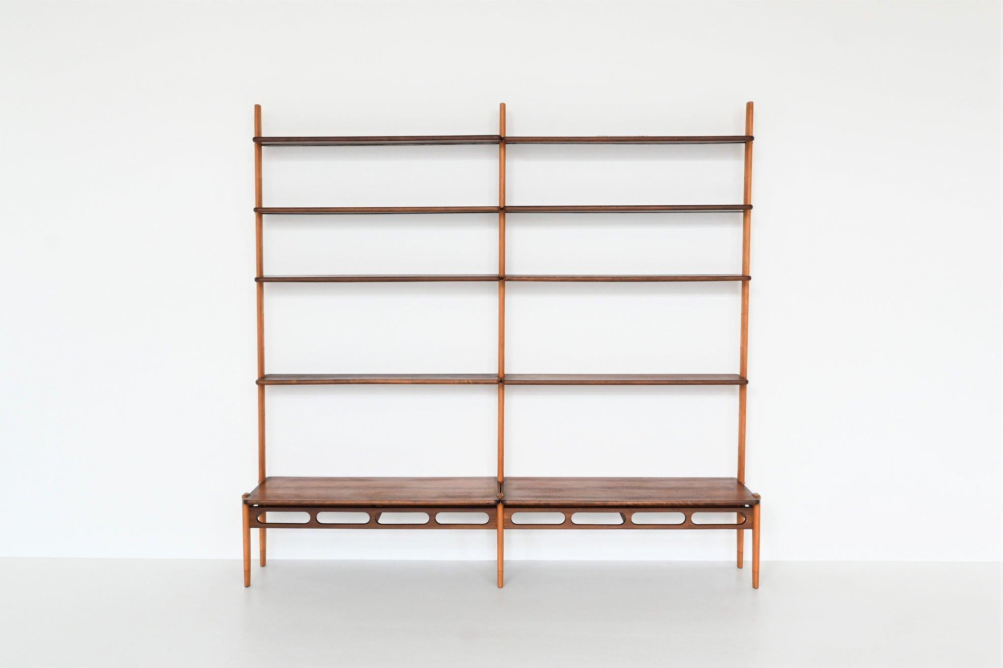 Beautiful modular two-tone wall unit designed by William Watting for Fristho, The Netherlands 1960. This open storage unit is made of solid teak shelves and solid beech uprights. It consists of a free standing bottom shelf and eight top shelves,