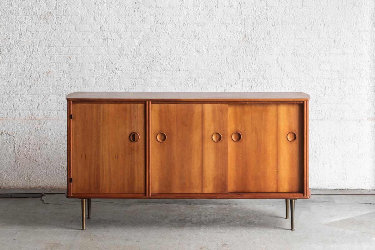 Sideboard designed by William Watting and produced by Fristho Franeker in the Netherlands around 1960. This sideboard has a walnut veneer body with 4 brass tapered legs underneath. Elegant piece which offers you a lot of storage space. In good