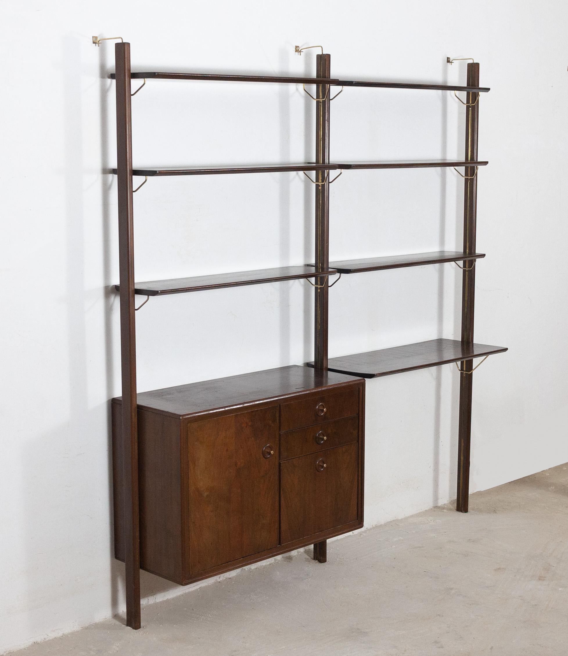 Rare wall system designed by William Watting for Fristho Franeker. The Netherlands, 1960s. Unique system featuring rails running down the uprights which the modular shelves and cabinets slide into for full vertical positioning freedom and brass