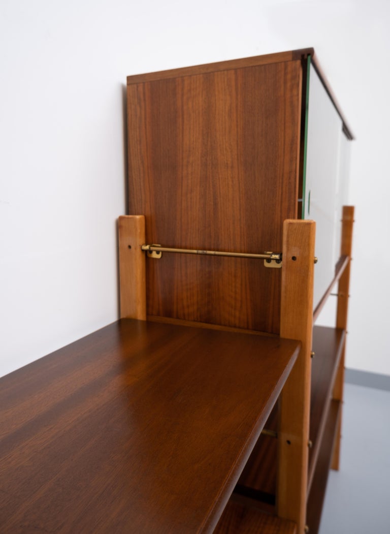 Vintage wall system by William Watting for Fristho Franeker from the 1950s. Beech frame with 3 solid teak shelves and cleverly designed brass hardware allowing two shelves to be positioned at the same height from a single central bar. Comes with 2