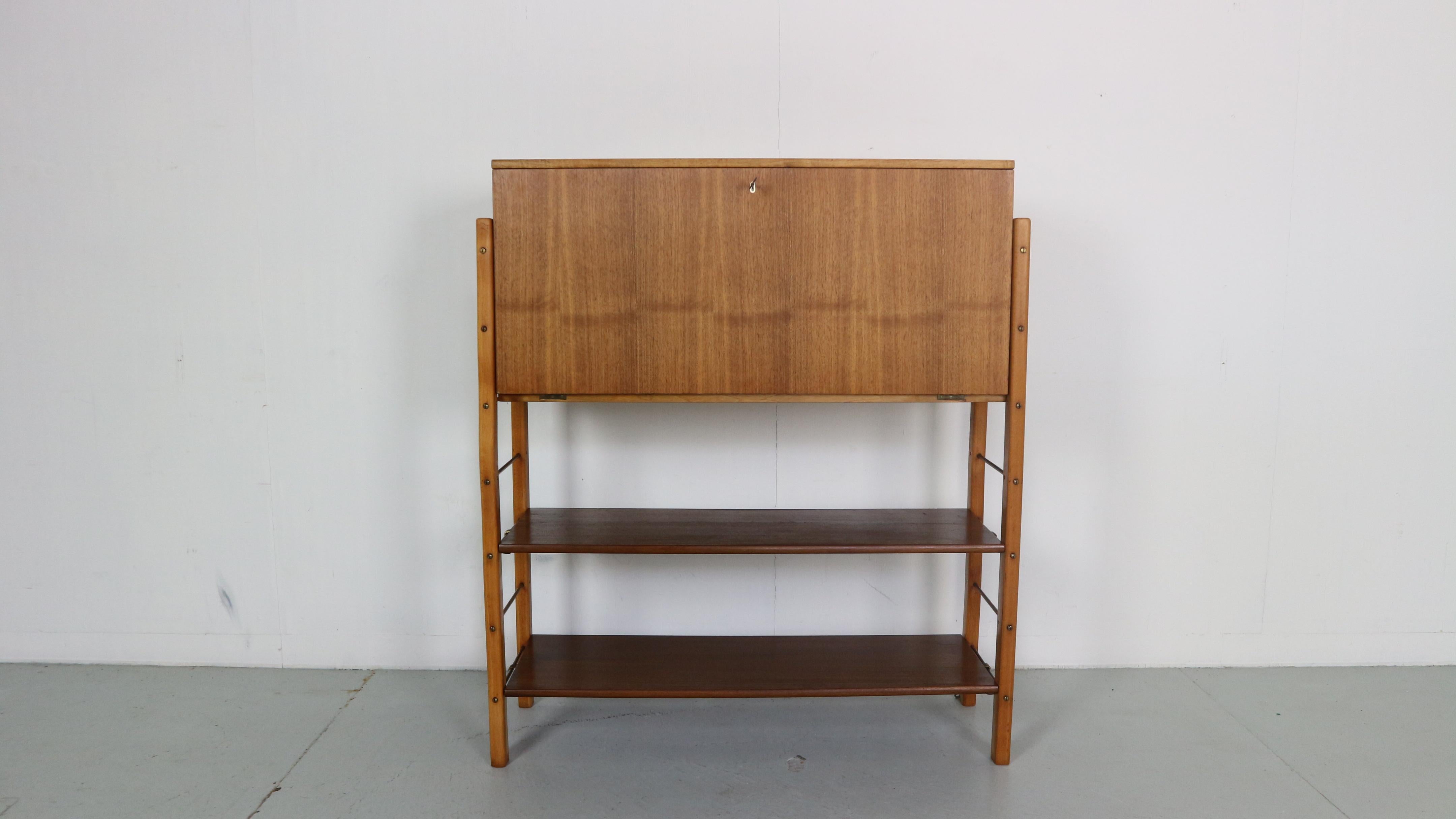 Mid- Century modern period wall system designed by William Watting for Fristho Franeker from the 1950s, Netherlands.

Free standing wall system has two shelves and a secretary cabinet.
You can place the shelves up or down depending on your own