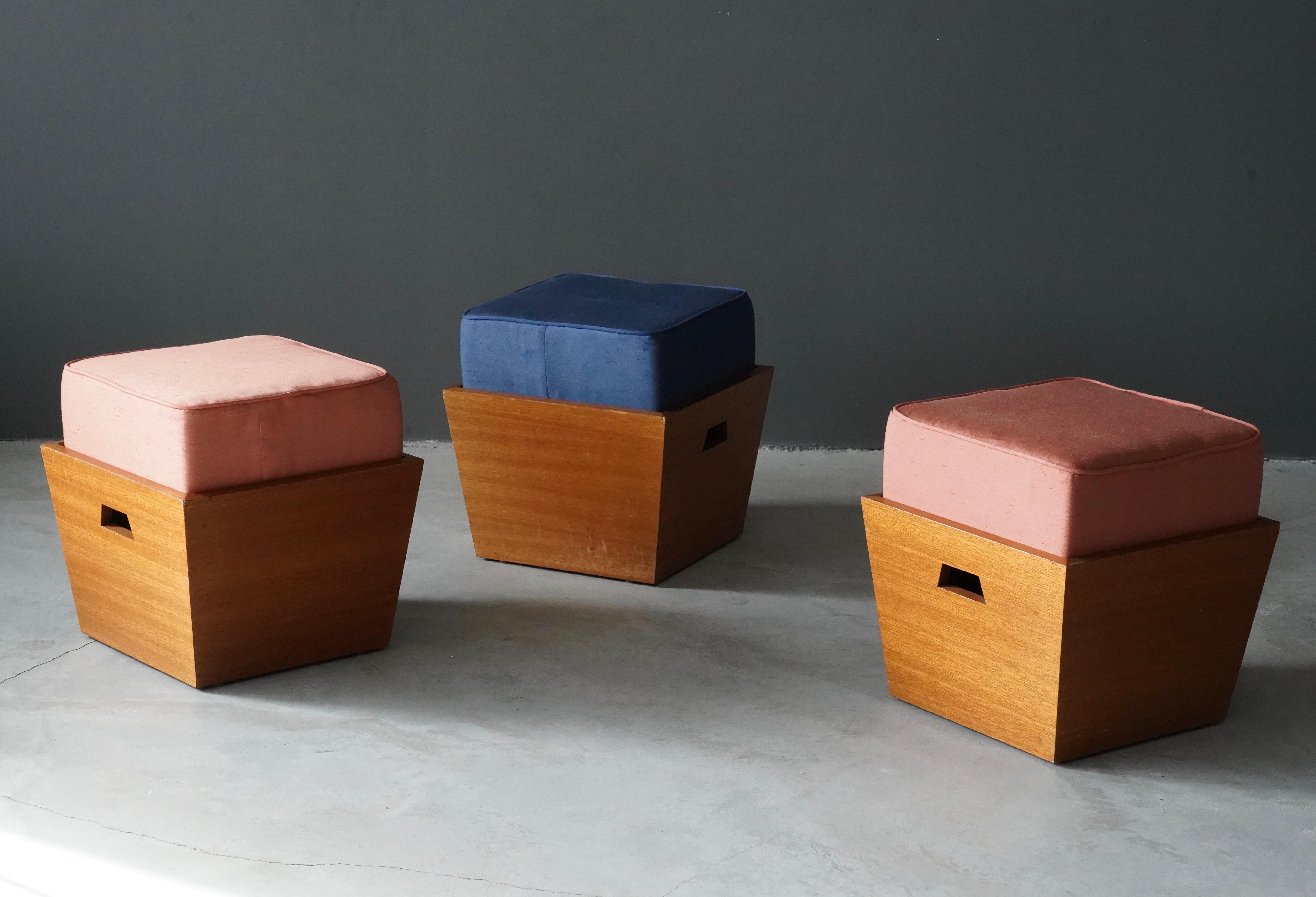 A set of three Hassocks / Stools, by William Wesley Peters, Hassocks from Focus House.

In oak, with vintage fabric in pink and blue fabric.

Produced by Kip Merritt for Taliesin Architects, 1984.

Other designers of the period include Frank