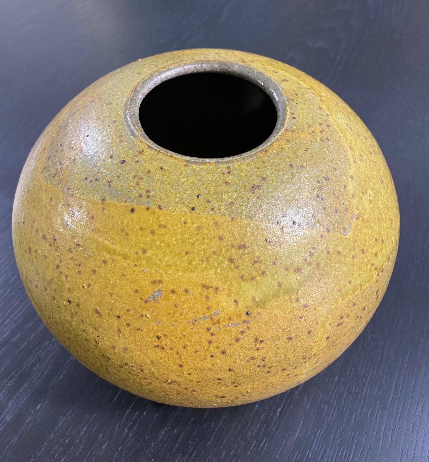 A wonderful work by East Coast/ Massachusetts master potter William Wymann. This piece features a rich, lava-like yellow speckled glaze. 

Wymann, who received his master's at Columbia University, was the founder (along with fellow potter Michael