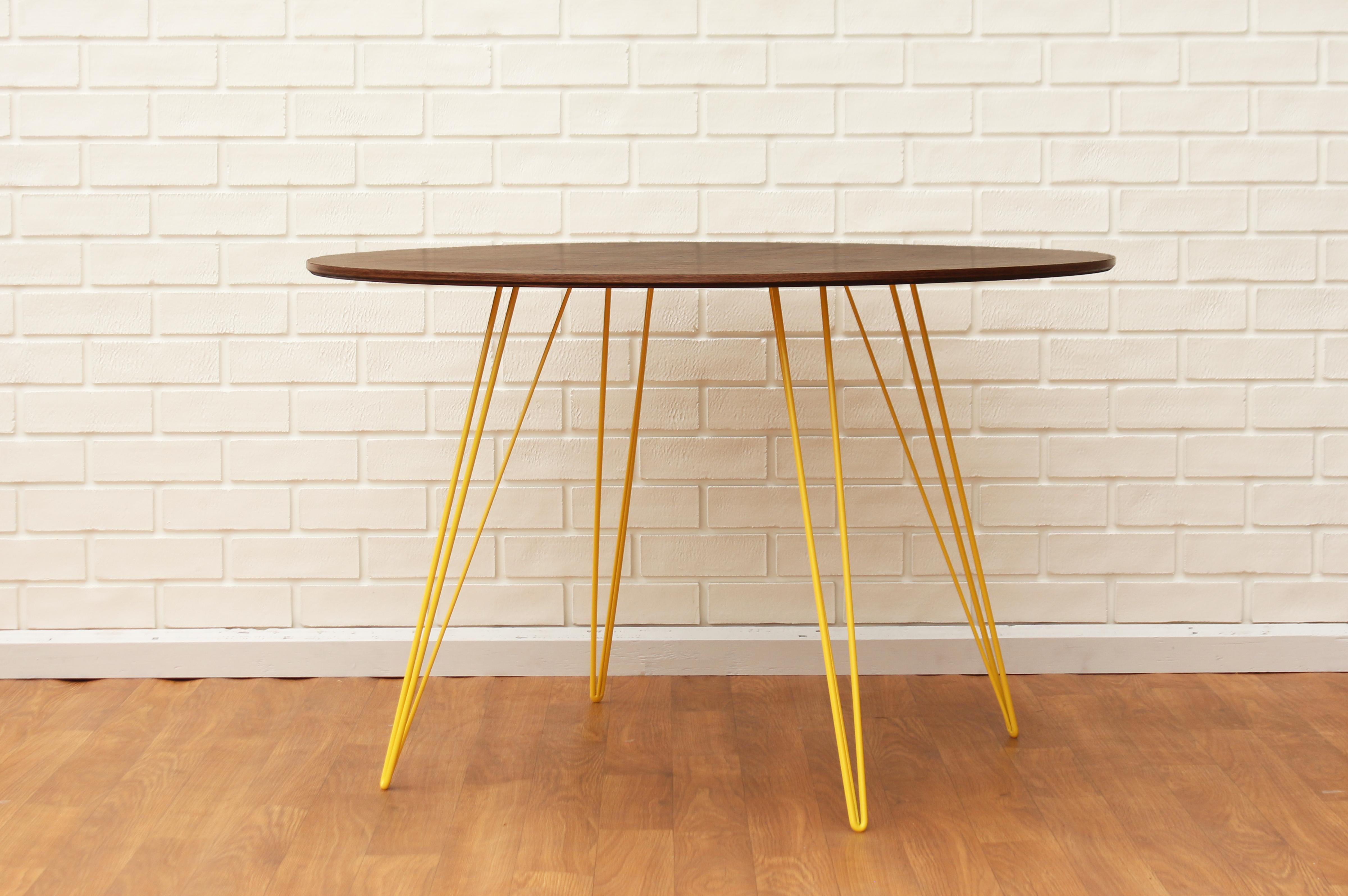 Une table fine, élégante et légère qui peut être personnalisée selon la forme, la taille et la couleur souhaitées. Cet article fabriqué à la main allie parfaitement des pieds industriels en épingle à cheveux à un plateau en bois biseauté. La beauté