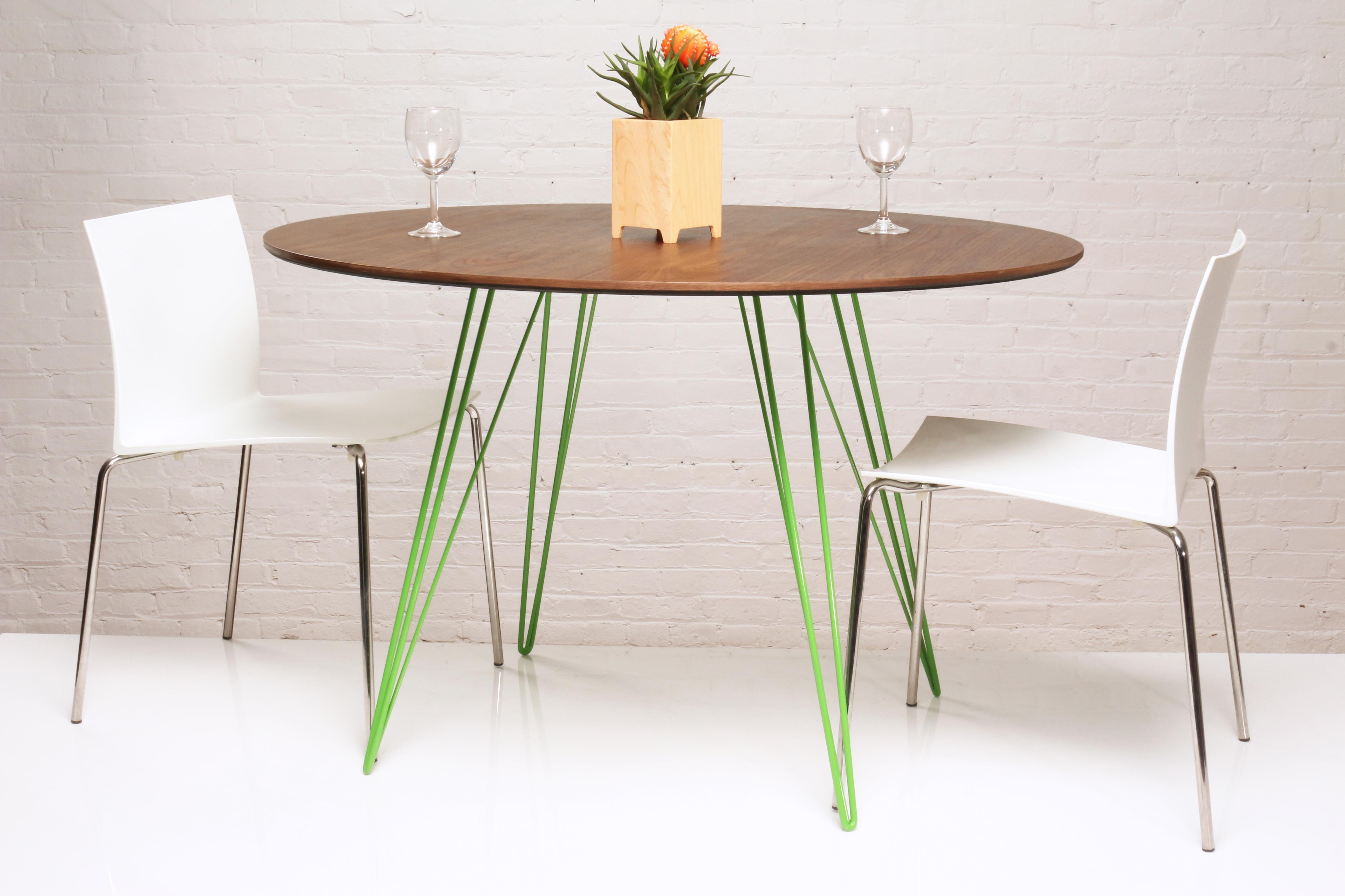 Une table fine, élégante et légère qui peut être personnalisée selon la forme, la taille et la couleur souhaitées. Cet article artisanal allie parfaitement des pieds industriels en épingle à cheveux à un plateau en bois biseauté. La beauté