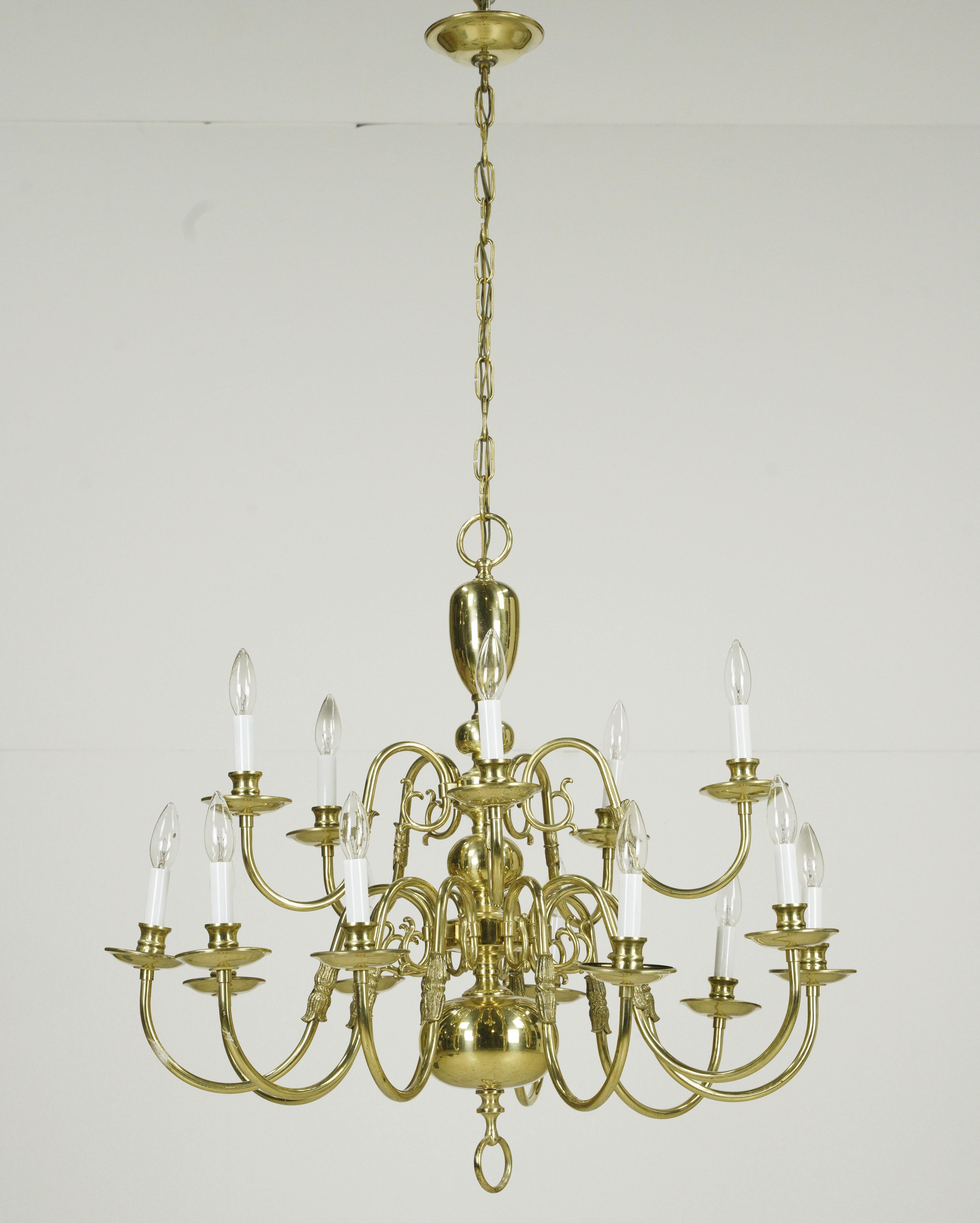 Lampadario a due piani Williamsburg in ottone lucido con quindici bracci. Buone condizioni con usura superficiale dovuta all'uso precedente e qualche piccola deformazione nei bracci. Vedere le foto. Questa lampada richiede 15 lampadine a candelabro.