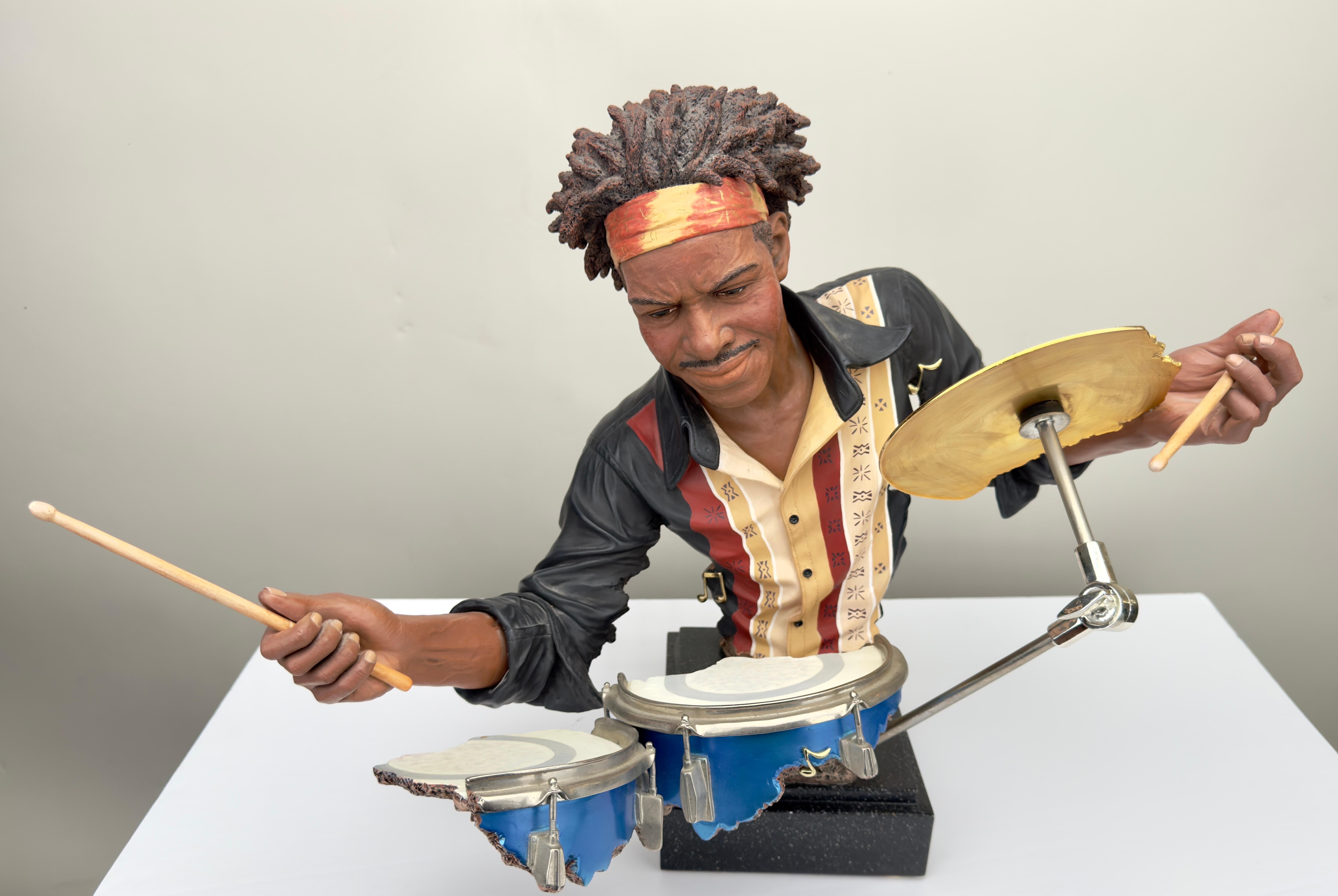 An exceptional drummer  sculpture by Willitts Designs International and Shen Lung. The sculpture is cold painted and made of hand cast resin. The drummer sculpture shows an african American man wearing a striped shirt and a bandana and is immersed