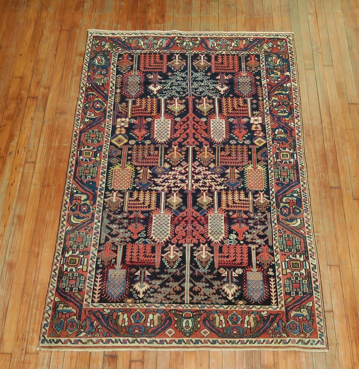 Stunning Persian Bakhtiari rug featuring a weeping tree of life motif on a navy ground. Great condition overall. Colors are very warm and subtle. Not too bright not too muted, circa 1920.

Measures: 4'2