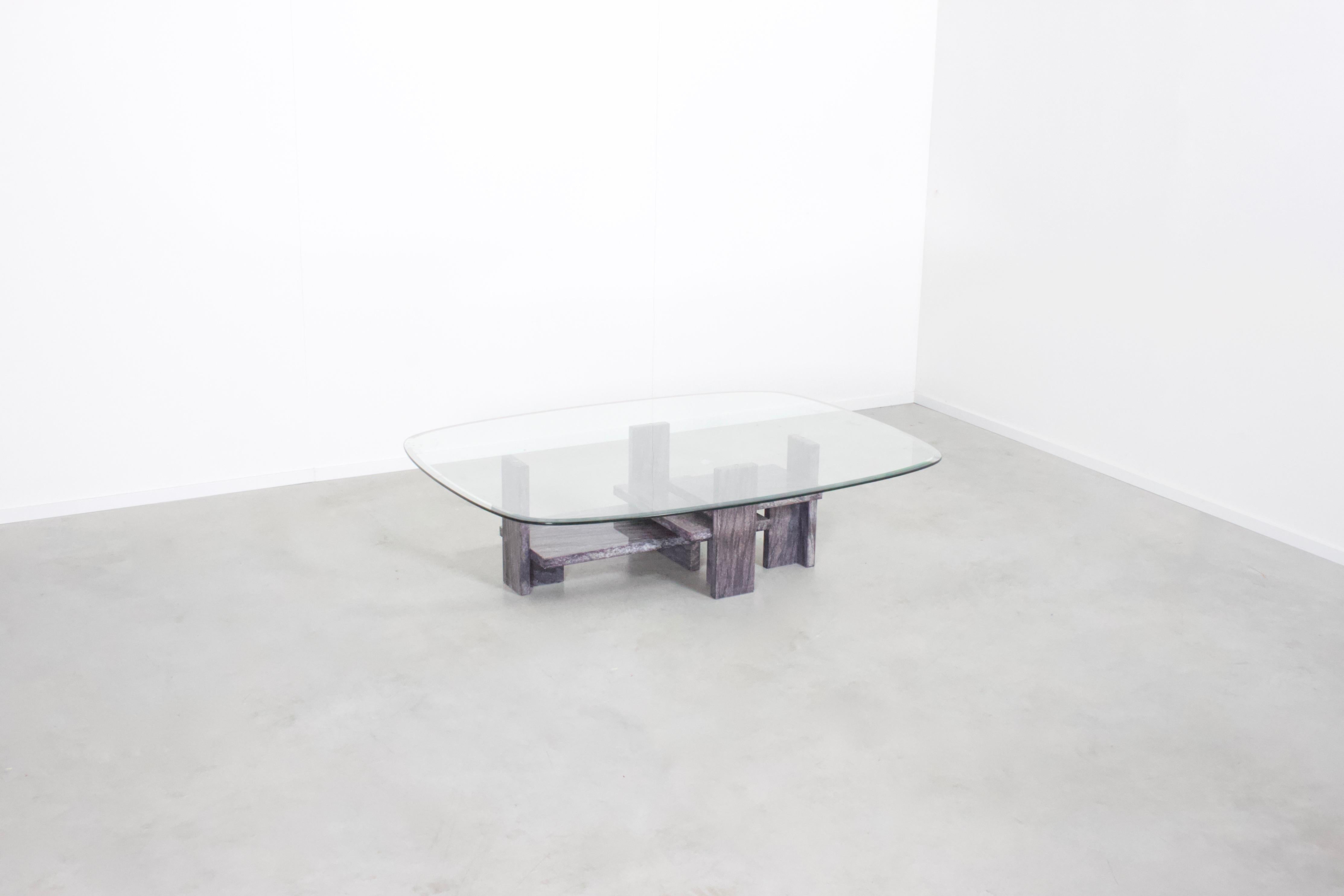 Sculptural coffee table by Willy Ballez in very good condition. 

Handmade in Belgium in the 1970s. 

The abstract base is made from solid marble in a Grey and Purple color. 

The oval top is made of glass and has a facet rim. 

We offer a variety